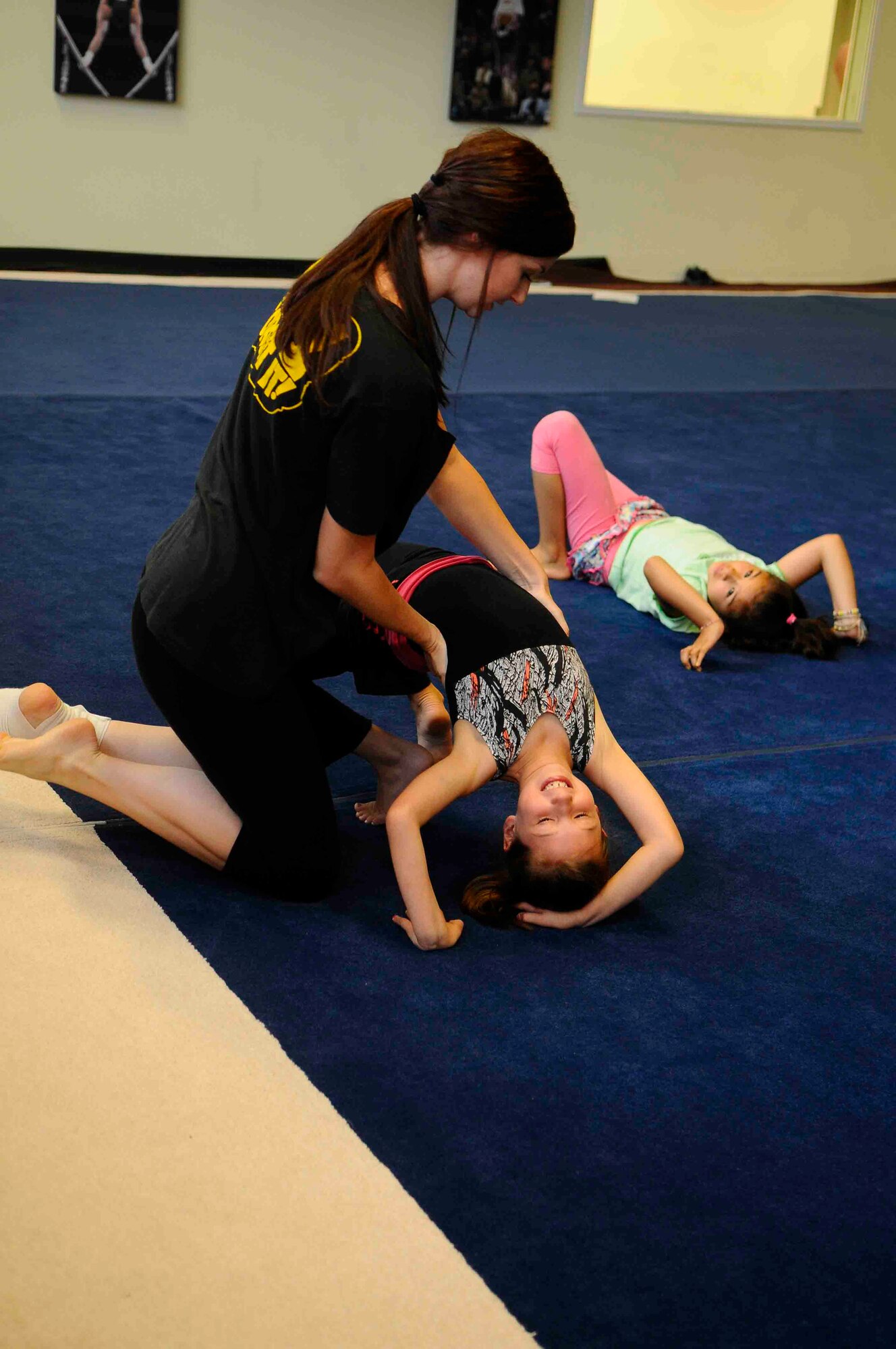 Jody Blevins, KMC Youth Center dance instructor, shows a Smash Camp attendee how to do a bridge during day one of Smash Camp Aug. 6 at the Youth Instructional building here. Smash camps is a five-day camp that allows children to try their hand at acrobatics, ballet, jazz, tap, Broadway, art, Yoga and Jeet Kun Do among other activities. (U.S. Air Force photo/Staff Sgf. Travis Edwards)