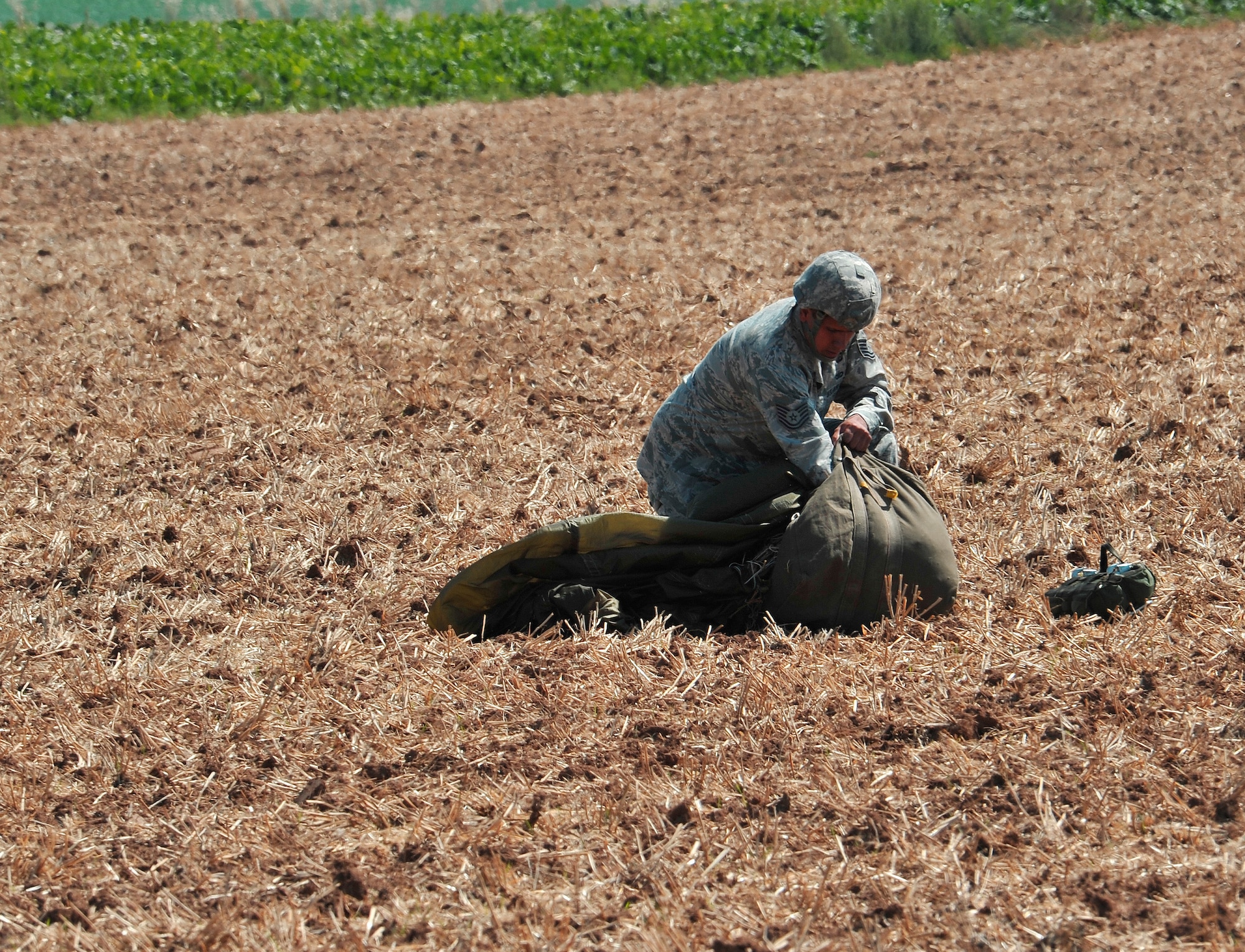 An Air Force paratrooper packs his parachute after landing on the drop zone Aug. 15, near Alzey Germany. Members of six NATO countries came together to trade jump tactics and techniques and got the opportunity to earn the other nation’s jump wings. (U.S. Air Force photo/Airman 1st Class Trevor Rhynes)