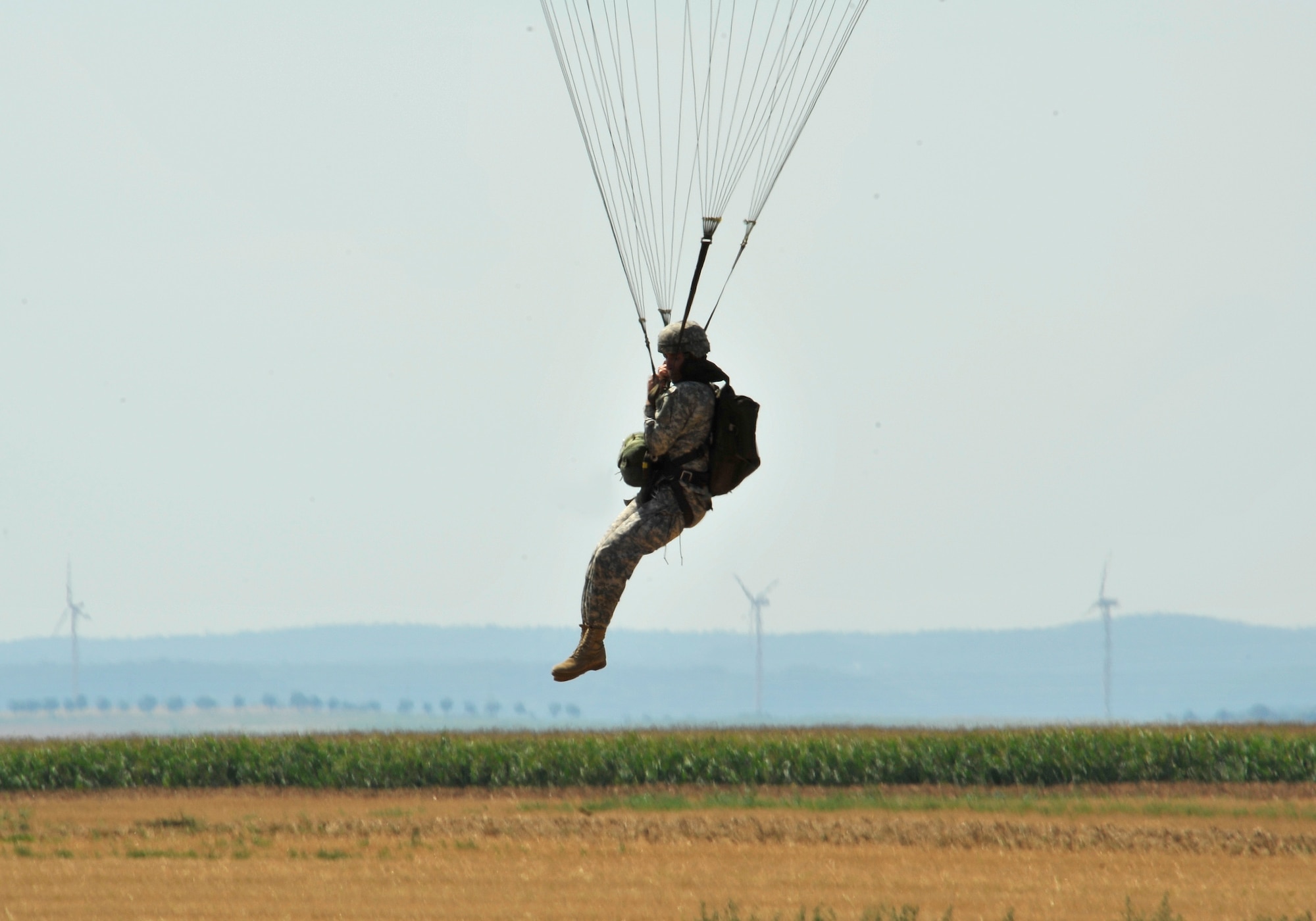 An Army paratrooper prepares to land on the drop zone Aug. 15, near Alzey, Germany. Members of six NATO countries came together to trade jump tactics and techniques and got the opportunity to earn the other nation’s jump wings. (U.S. Air Force photo/Airman 1st Class Trevor Rhynes)
