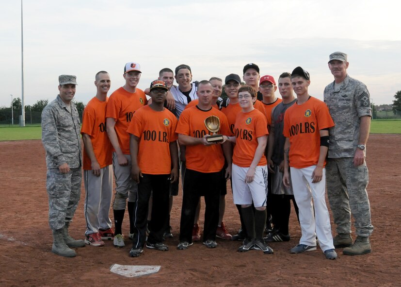 RAF MILDENHALL, England – Members of the 100th Logistics Readiness Squadron softball team receive the intramural softball championship trophy following the championship match against the 100th Security Forces Squadron Aug. 14, 2012, at RAF Mildenhall. Col. Christopher Kulas, left, 100th Air Refueling Wing commander, and Chief Master Sgt. Christopher Powell, right, 100th ARW command chief, presented the trophy. (U.S. Air Force photo by Tech. Sgt. Neal X. Joiner)