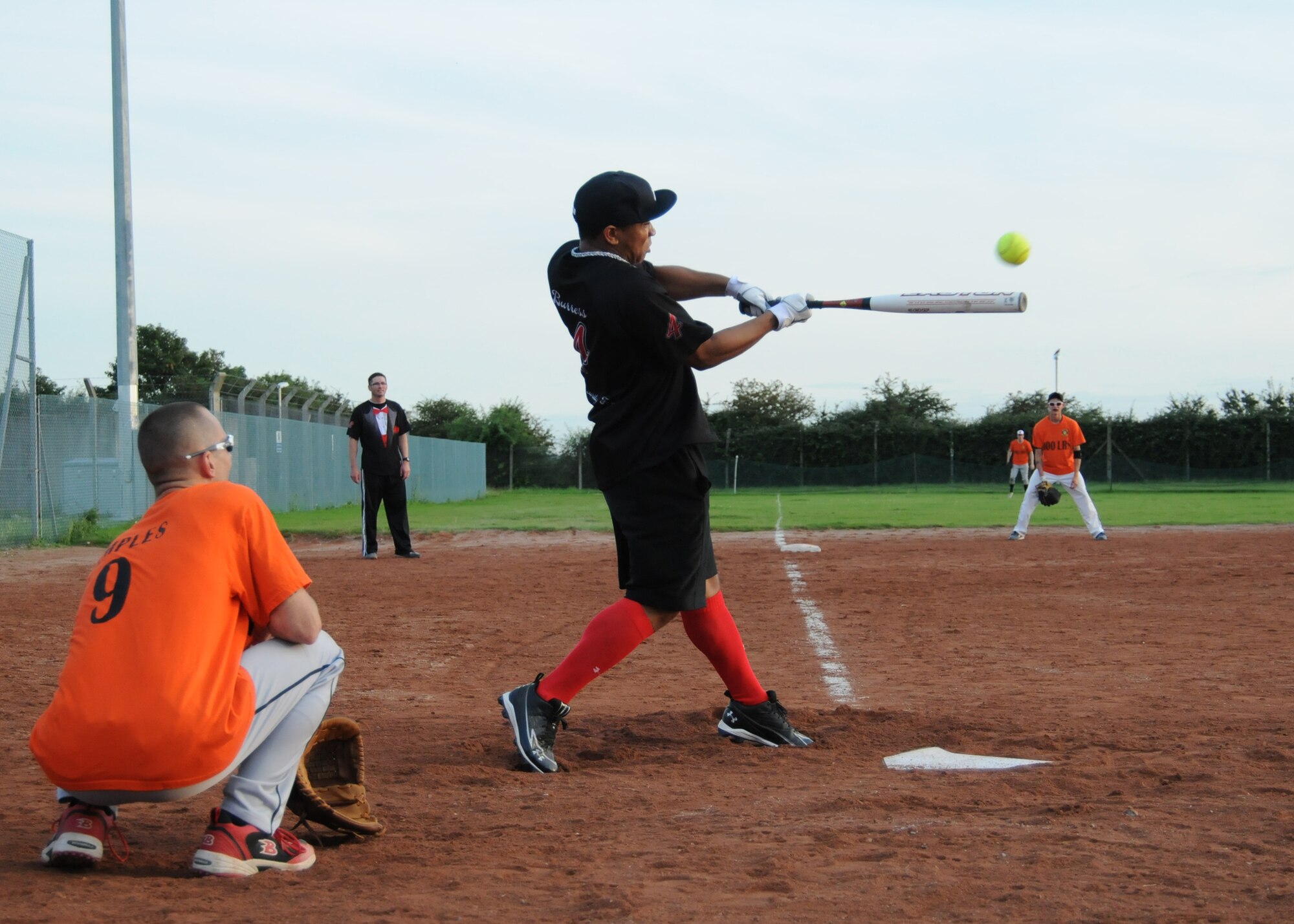 RAF MILDENHALL, England – Brandon Burress, 100th Security Forces Squadron, hits the ball as Gabriel Temples, 100th Logistics Readiness Squadron, catches during the Team Mildenhall intramural softball championship Aug. 14, 2012. The 100th LRS defeated the 100th SFS 8 – 4 to claim the championship trophy. (U.S. Air Force photo by Tech. Neal X. Joiner)