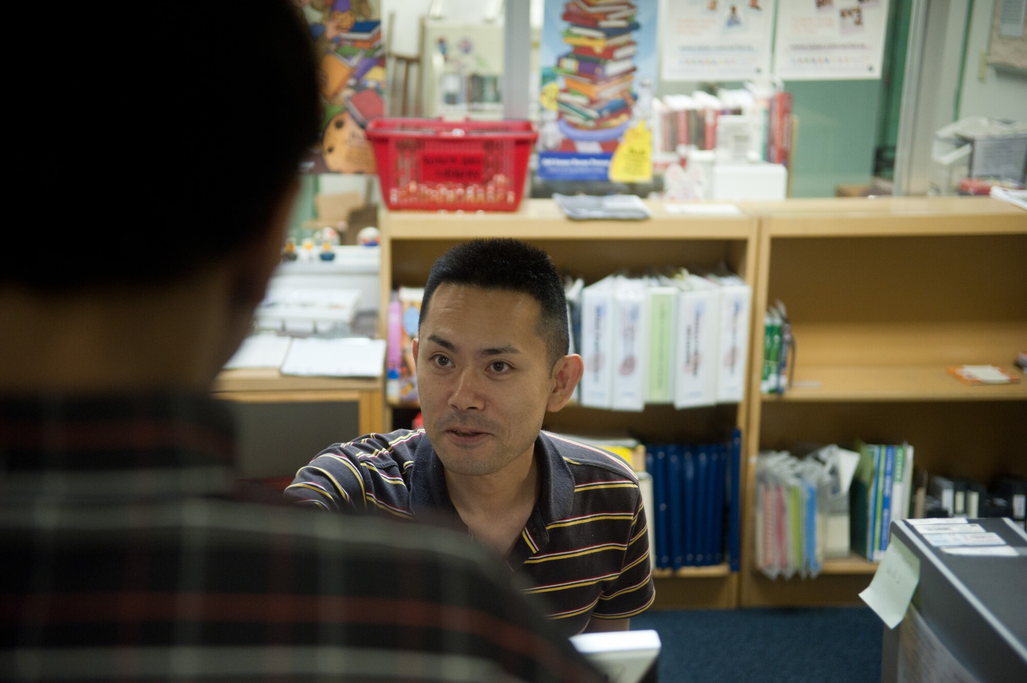 YOKOTA AIR BASE, Japan -- Jun Sekino, library technician, helps a customer at the Base Library at Yokota Air Base, Japan. The library has won numerous awards in the past six years, including the 2011 Pacific Air Forces Outstanding Library Program award. (U.S. Air Force photo by Airman 1st Class John D. Partlow)