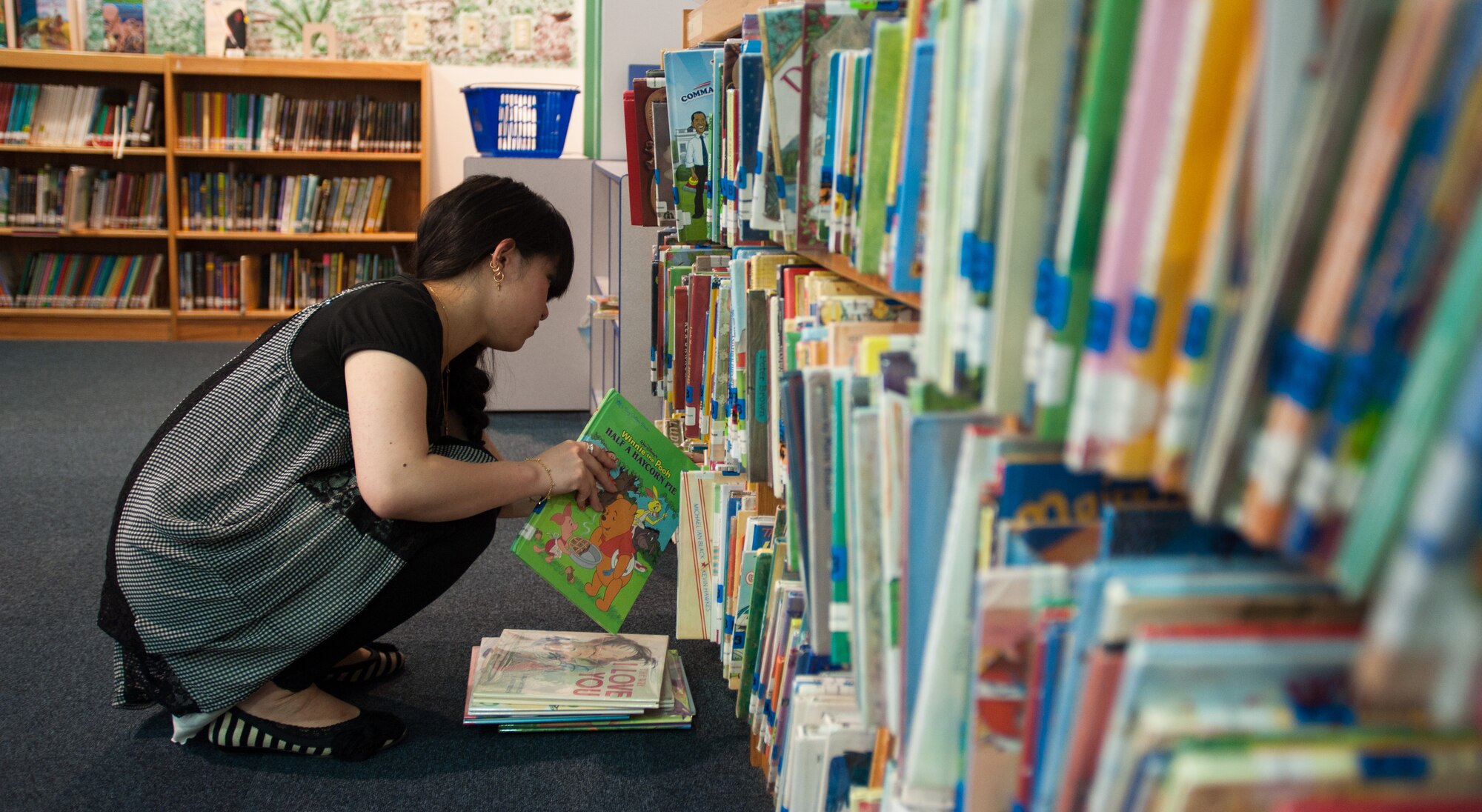 YOKOTA AIR BASE, Japan -- Asuka Yokoyama, a library clerk, restocks a bookshelf at the Base Library at Yokota Air Base, Japan, on Aug. 15, 2012. More than 60,000 books can be found at the Base Library, all of which can be checked-out for up to four week. (U.S. Air Force photo by Airman 1st Class John D. Partlow)