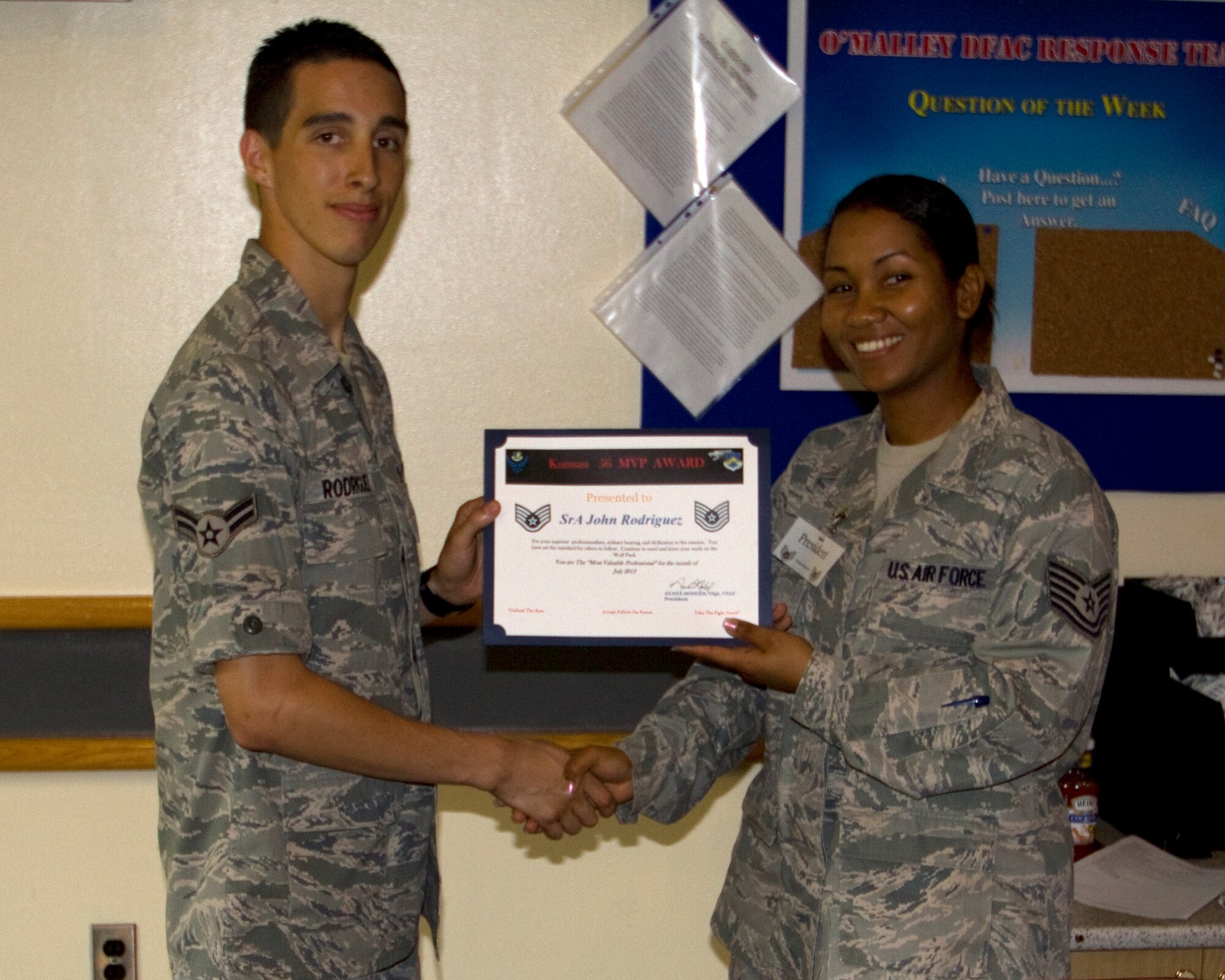 Airman 1st Class John Rodriguez, left, 8th Communications Squadron, accepts the Most Valuable Professional Award from Kunsan Team 5/6 president Tech. Sgt. Ayana Hodges. Team 5/6 created this monthly award as a way for junior NCOs to recognize deserving Airmen. (U.S. Air Force photo/Staff Sgt. Gregory Day)