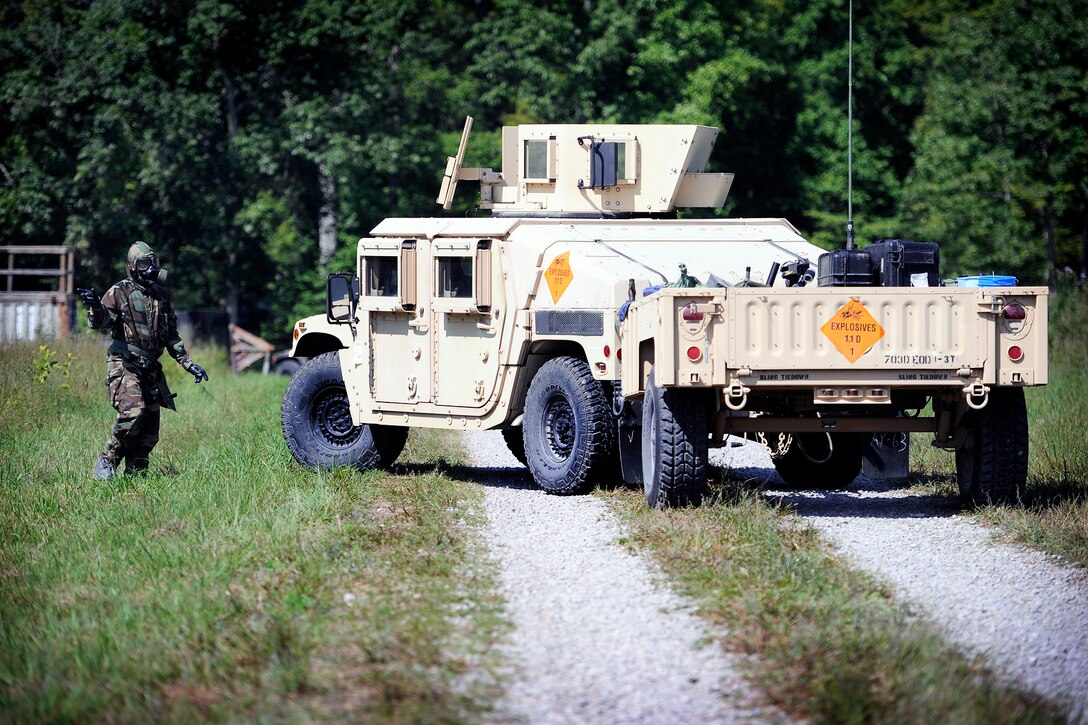 Army Sgt. Matthew Bagley, left, guides the team's Humvee while suited up in chemical warfare protective gear during the first 20th Support Command's competition for Explosive Ordnance Disposal Team of the Year on Fort Knox, Ky., Aug. 15, 2012. Bagley is assigned to the 663rd Ordnance Company, 242nd Explosive Ordnance Disposal Battalion, Fort Carson, Colo.