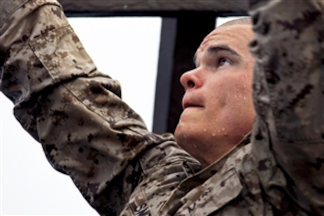 U.S. Marine Lance Cpl. Justin Smith climbs across monkey bars during a water obstacle course at Arta Beach in Djibouti, Aug. 11, 2012. Smith, a assaultman, is assigned to Charlie Company, Battalion Landing Team, 1st Battalion, 2nd Marine Regiment, 24th Marine Expeditionary Unit. The French 5th Marine Regiment hosted the course.