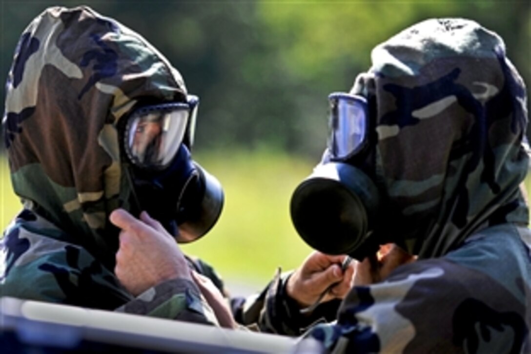 Army Staff Sgt. Christopher Thompson and Sgt. Matthew Bagley use the “buddy” system to ensure proper seals as they don their chemical warfare protective gear during the first 20th Support Command's competition for Explosive Ordnance Disposal Team of the Year on Fort Knox, Ky., Aug. 14, 2012. Thompson, a team leader, and Bagley are assigned to the 663rd Ordnance Company, 242nd Explosive Ordnance Disposal Battalion, Fort Carson, Colo.