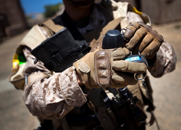 U.S. Marine Lance Cpl. Tory Martin, a rifleman with 3rd Platoon, India Company, 3rd Battalion, 3rd Marine Regiment, and 20-year-old native of Twentynine Palms, Calif., replaces the safety pin of a Stingball grenade after using it during a non-lethal weapons training scenario in a simulated urban village on Marine Corps Training Area Bellows, Hawaii, Aug. 15, 2012. The training was part of a two-week test readiness review fielded by the Quantico, Va.-based Joint Non-Lethal Weapons Directorate and the Marine Corps Forces, Pacific Experimentation Center. The DoD Non-Lethal Weapons Program, headed by Commandant of the Marine Corps Gen. James Amos, trains operating forces on escalation of force options to minimize casualties and collateral damage, said Kelley Hughes, a directorate spokesperson.