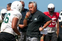 University of Hawaii head coach Norm Chow directs exercises at the Warriors practice Aug. 15 at Earhart Field, Joint Base Pearl Harbor-Hickam, Hawaii. The team lived and worked out on Hickam Field from Aug. 13-17 due to the UH dormitories being cleaned and prepared for the start of the fall session. The Warriors are scheduled to be on the road for their opener Sept. 1, in Los Angeles, against the University of Southern California Trojans. (U.S. Air Force photo/Staff Sgt. Mike Meares)