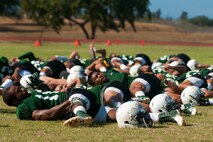 University of Hawaii football players stretch before a practice Aug. 17 at Earhart Field, Joint Base Pearl Harbor-Hickam, Hawaii. The team lived and worked out on Hickam Field from Aug. 13-17 due to the UH dormitories being cleaned and prepared for the start of the fall session. The Warriors are scheduled to be on the road for their opener Sept. 1, in Los Angeles, against the University of Southern California Trojans. (U.S. Air Force photo/Staff Sgt. Mike Meares)