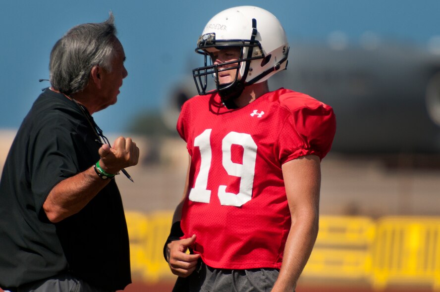 Norm Chow, University of Hawaii head coach, works with starting quarterback Sean Schroeder during an Aug. 15 Warriors practice at Earhart Field, Joint Base Pearl Harbor-Hickam, Hawaii. The team lived and worked out on Hickam Field from Aug. 13-17 due to the UH dormitories being cleaned and prepared for the start of the fall session. The Warriors are scheduled to be on the road for their opener Sept. 1, in Los Angeles, against the University of Southern California Trojans. (U.S. Air Force photo/Staff Sgt. Mike Meares)