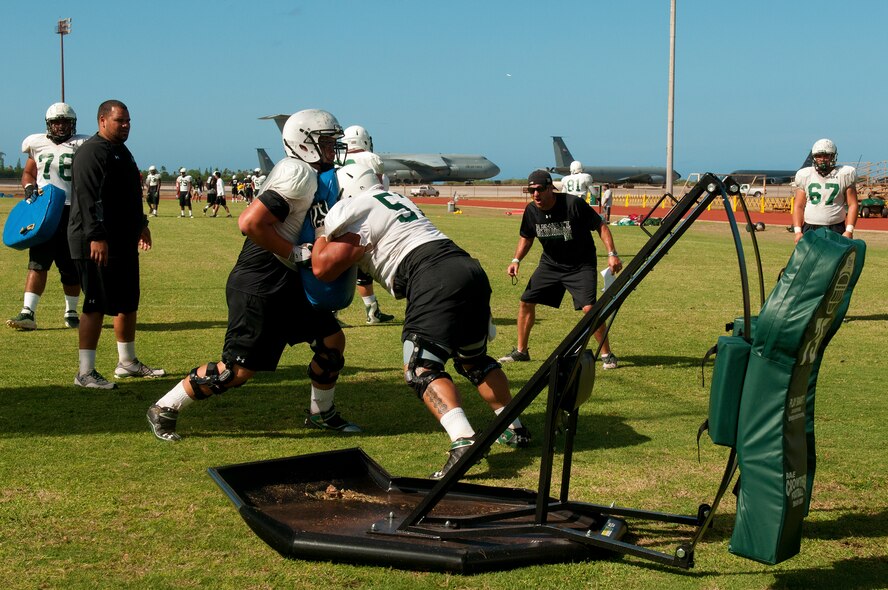 The University of Hawaii offensive line works on blocking drills during an Aug. 15 practice at Earhart Field, Joint Base Pearl Harbor-Hickam, Hawaii. The team lived and worked out on Hickam Field from Aug. 13-17 due to the UH dormitories being cleaned and prepared for the start of the fall session. The Warriors are scheduled to be on the road for their opener Sept. 1, in Los Angeles, against the University of Southern California Trojans. (U.S. Air Force photo/Staff Sgt. Mike Meares)