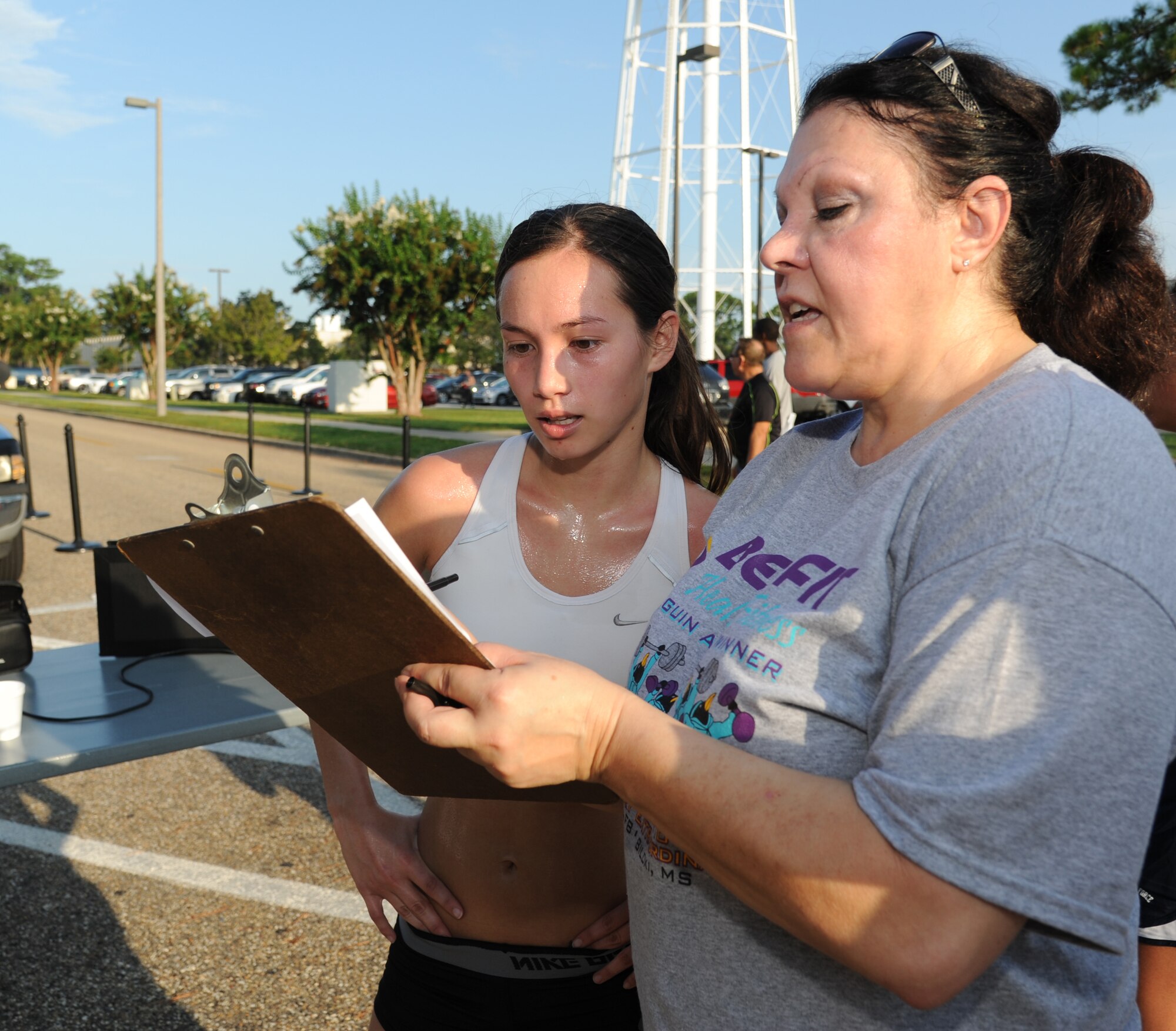 Jennifer Flanery, first place female, verifies her time of 22:17 with Maria Creel, CSC, following the Fisher House 5K benefit run/walk Aug. 17, 2012, beginning and ending at the Blake Fitness Center, Keesler Air Force Base, Miss.  Prizes were awarded to the first, second and third place male and female.  The event raised $946.50, which will be donated to the Keesler Fisher House.  Jennifer is the fiance of Phillip Poundstone, 333rd Training Squadron.  David Lane, 81st Inpatient Operation Squadron, finished first with a time of 20:55.  (U.S. Air Force photo by Kemberly Groue)