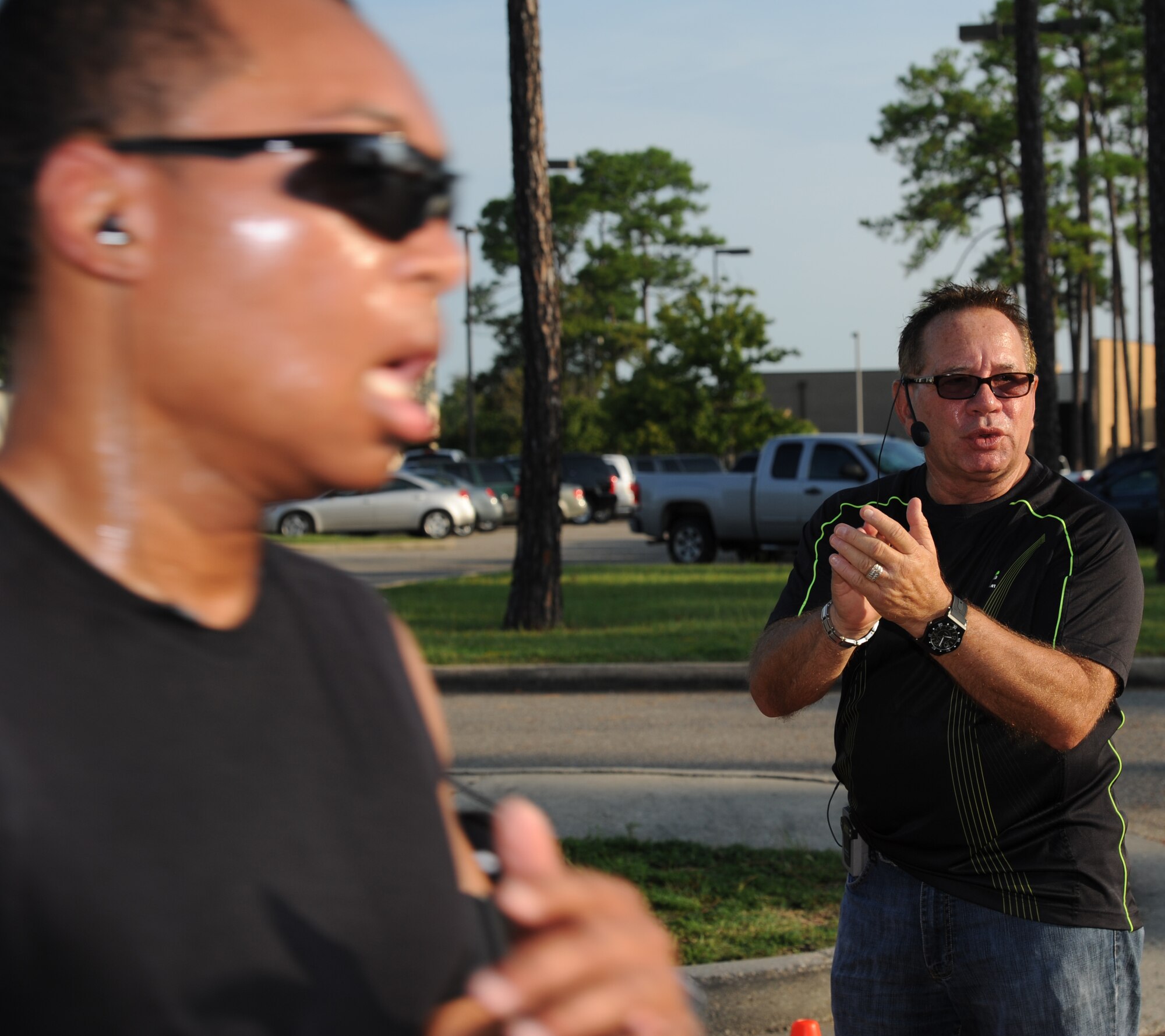 Thaddeus Faxon, 81st Contracting Squadron, crosses the finish line with a time of 23:10 as Bill Jinske, Keesler’s fitness and sports director, cheers him on during the Fisher House 5K benefit run/walk Aug. 17, 2012, beginning and ending at the Blake Fitness Center, Keesler Air Force Base, Miss.  Prizes were awarded to the first, second and third place male and female.  The event raised $946.50, which will be donated to the Keesler Fisher House.  (U.S. Air Force photo by Kemberly Groue)