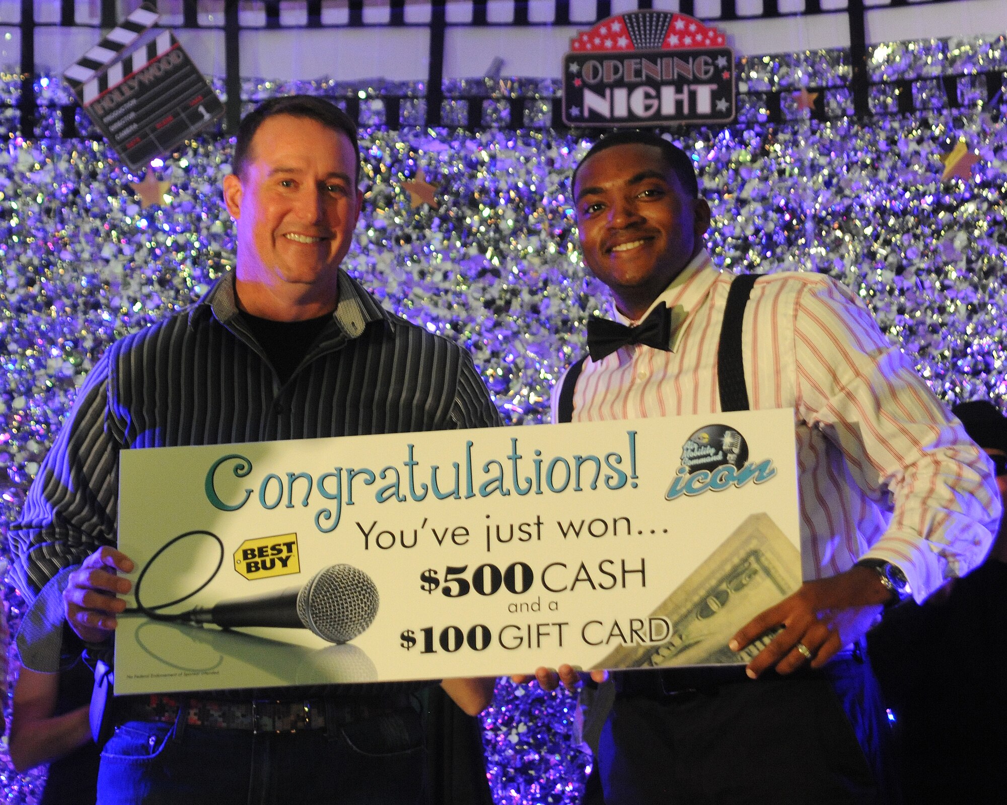 Col. Tim Bush, 319th Air Base Wing commander, presents Senior Airman Marshall Merriweather, 319th Logistics Readiness Squadron, with the first prize for the 2012 Grand Forks Air Force Base Air Mobility Command Icon competition, Aug. 16, 2012. Merriweather will represent Grand Forks AFB at the AMC Icon finals at Scott AFB, Ill., where he will have a chance to win an audition for the world renowned Air Force Tops in Blue. (U.S. Air Force photo/Airman 1st Class Xavier Navarro)
