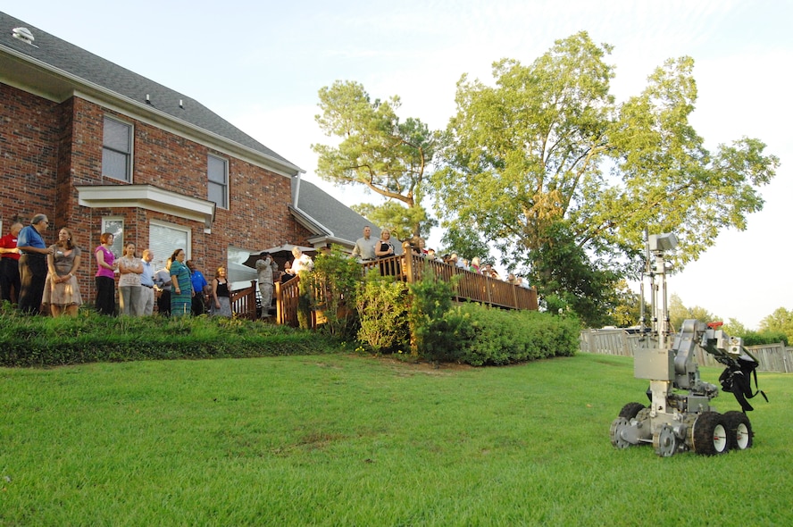 Community leaders visiting Shaw Air Force Base, S.C., from 9th Air Force wings across the southeastern United States watch as 20th Civil Engineer Squadron explosive ordinance disposal technicians perform an explosive device detonation demonstration with a percussion actuated neutralizer (robot), at Shaw AFB, S.C., Aug. 15, 2012.   The EOD technicians use PANs to remotely open boxes, bags and other items that might contain explosive devices.(U.S. Air Force photo by Airman Nicole Sikorski/ Released)
