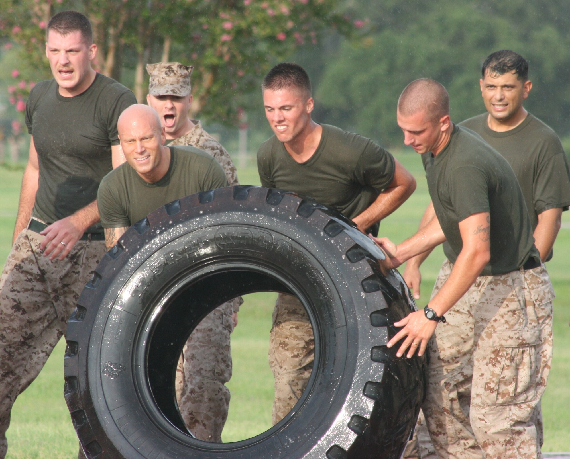 Sgt. Daniel Krause, Pfc. Matthew Davis, and Sgt. Jacob Urban, Keesler Marine Corps Detachment and meteorology and oceanographic analyst forecast schoolhouse flip a 200 pound tire in the MARDET Field Meet relay race Aug. 3, 2012, at the Triangle track,  Keesler Air Force Base, Miss.  Each team had to flip a tire around a 400 meter track to complete their portion of the relay.  (U.S. Marine Corps photo by Marine Staff Sgt. Christopher Lambert)
