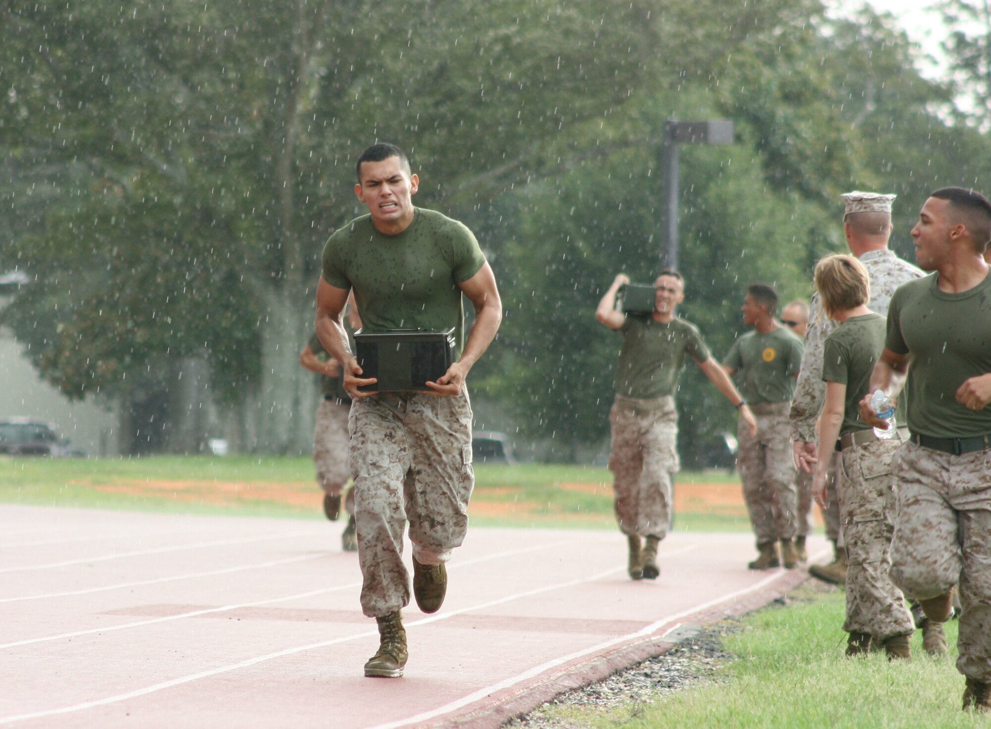 Rainfall does little to slow Lance Cpl. John Puma, Keesler Marine Corps Detachment as he competes in the ammunition carry portion of a relay race held during the MARDET Field Meet Aug. 3, 2012, at the Triangle track, Keesler Air Force Base, Miss.  The competitors each had to complete a grueling 1200 meter course while carrying 30lb ammunition cans.  (U.S. Marine Corps photo by Marine Staff Sgt. Christopher Lambert)