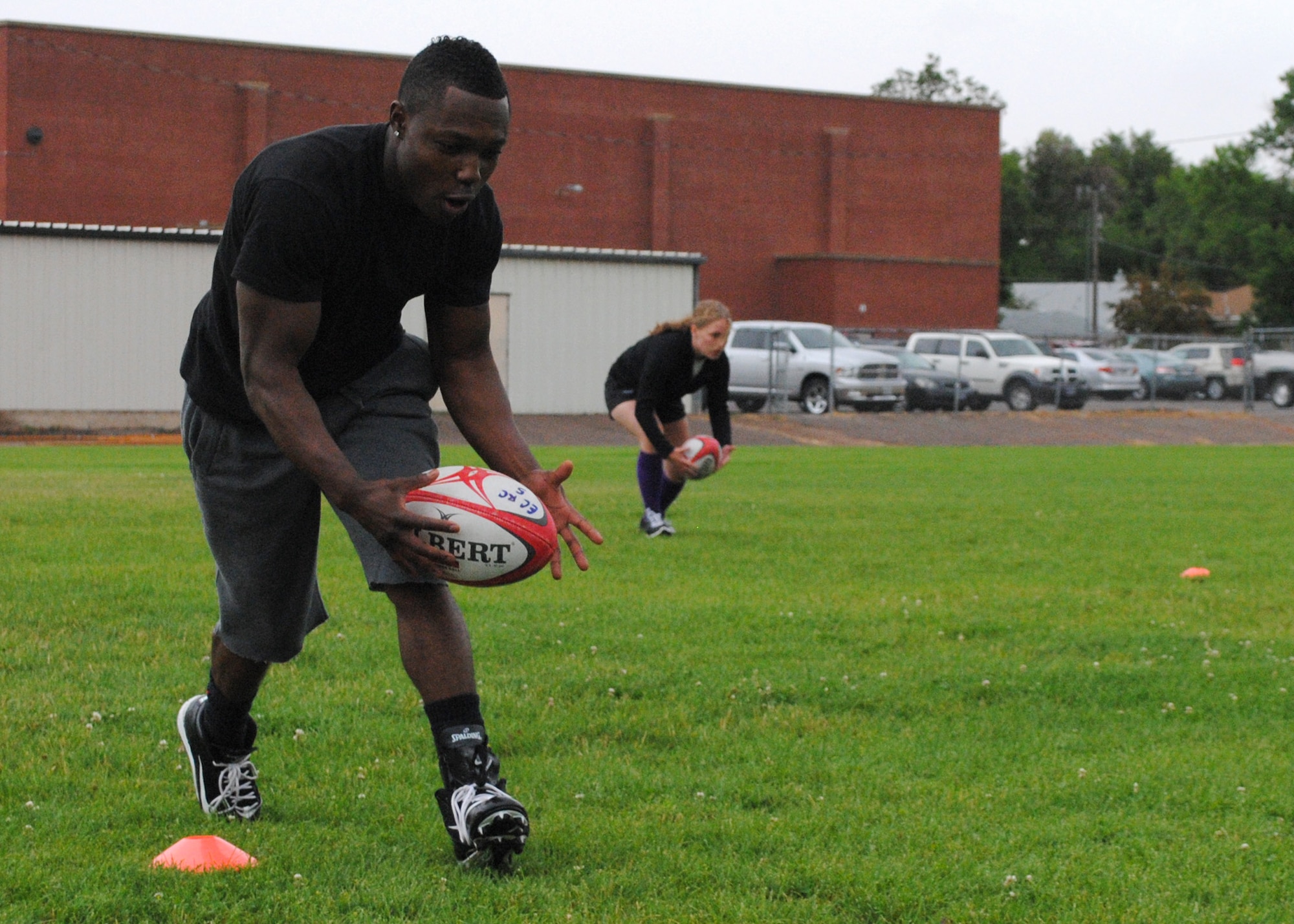Estimon and Dorshorst (background) practice a concentration drill during the rugby clinic at the Paris Gibson Education Center on Aug. 15.  Although Dorshorst has been playing rugby for a number of years, Estimon attended the clinic to learn the sport.  (U.S. Air Force photo/Airman 1st Class Katrina Heikkinen)