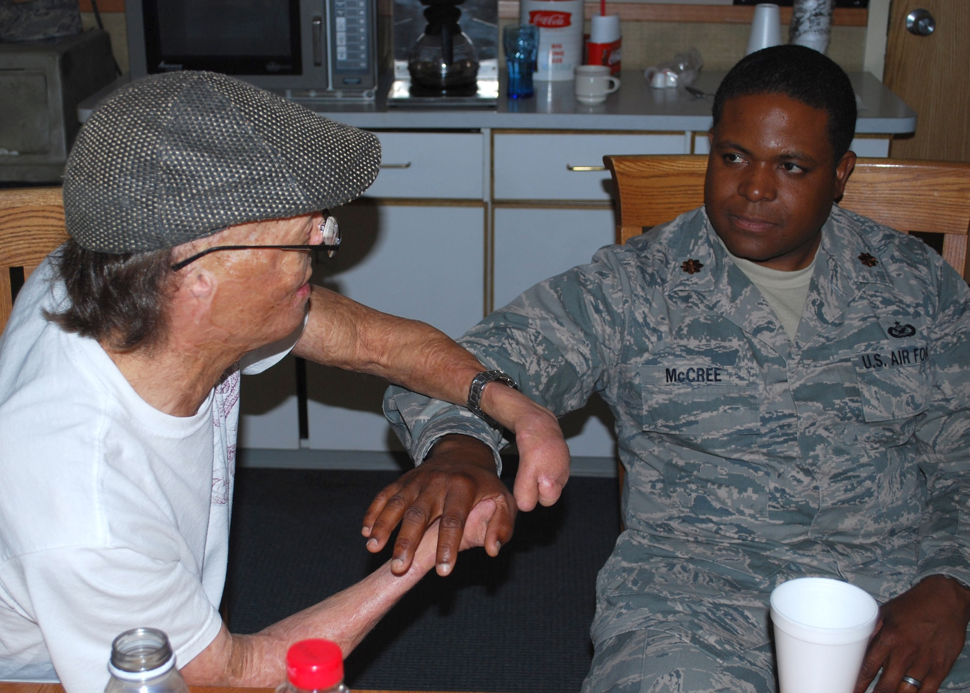 Dan Caro uses the hand of Maj. Jason McCree, Air Force Global Strike Command public affairs, to show Airmen how doctors were able to give him a moveable thumb through surgery.  Caro has undergone more than 80 surgeries following third-degree burns he received on more than 80 percent of his body as a toddler.  He has since followed, and achieved, his dream of becoming a professional drummer.  (U.S. Air Force photo/Airman 1st Class Cortney Paxton)