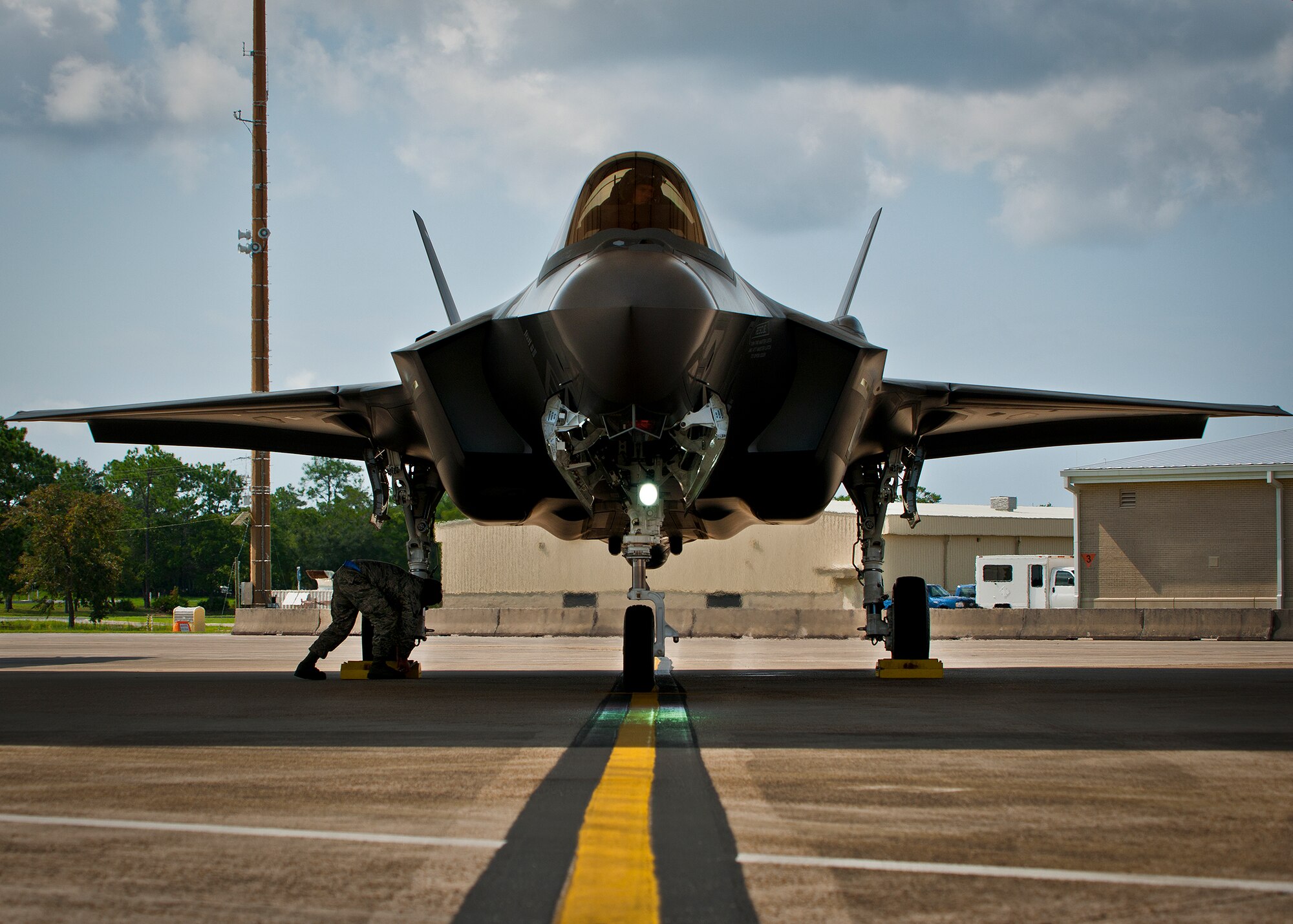 A maintainer secures the chocks on the wheel of an F-35A Lightning II joint strike fighter after its sortie at Eglin Air Force Base, Fla., Aug. 16.  The sortie marked the 100th F-35A mission flown at Eglin.  The Air Force and Marine Corps pilots accomplish morning and afternoon sorties every day, depending on the weather.  Together, the A and B variant F-35 pilots have flown almost 200 sorties at Eglin.  (U.S. Air Force photo/Samuel King Jr.)