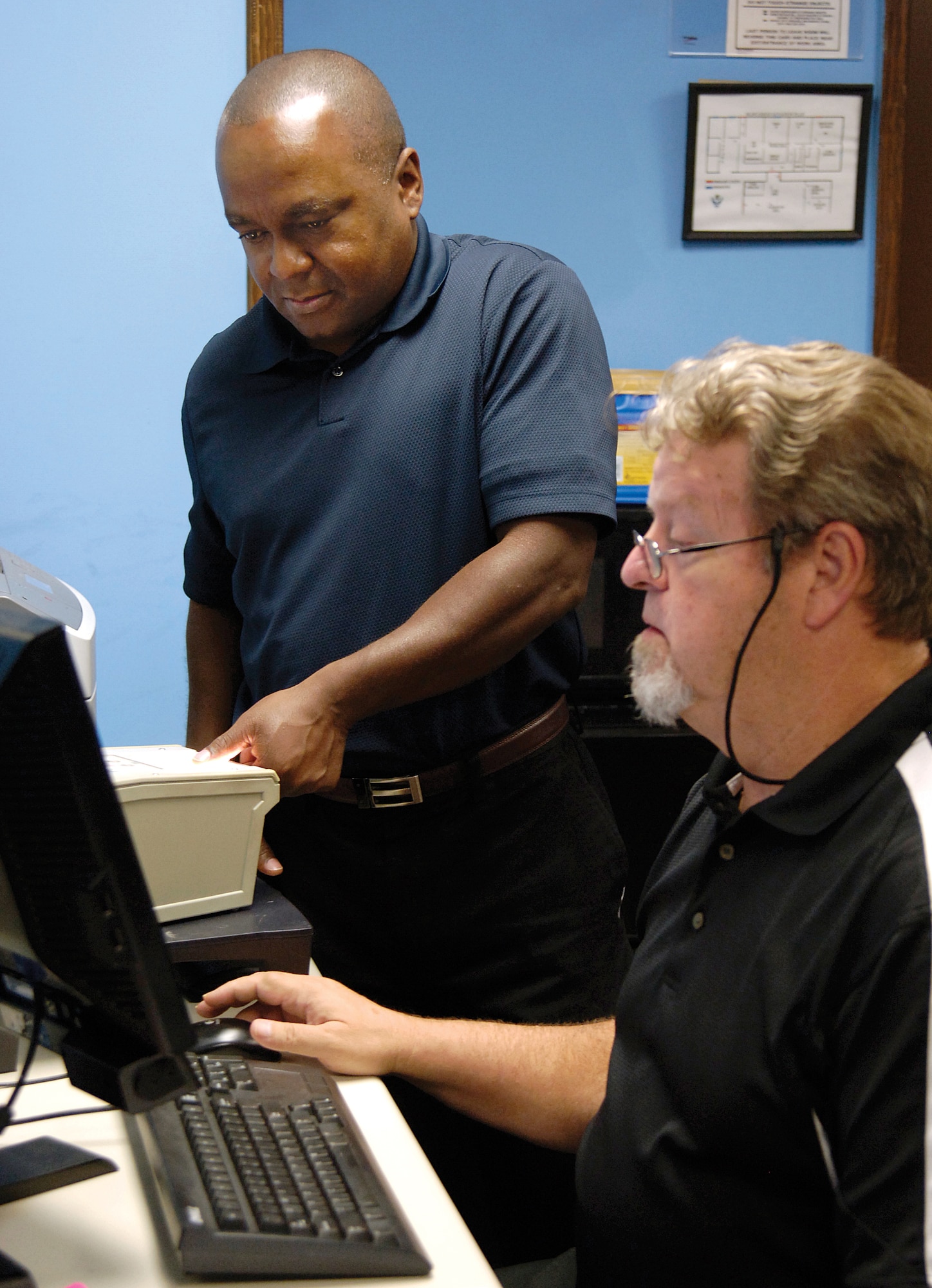 Personnel security specialist Bill King records Marcus Ward’s fingerprints at the 72nd Air Base Wing Information Protection office. Mr. Ward is a new-hire into the 431st Supply Chain Management Squadron. The IP office and its four-person staff print most Tinker Air Force new-hires during their security investigation. (Air Force photo by Margo Wright)