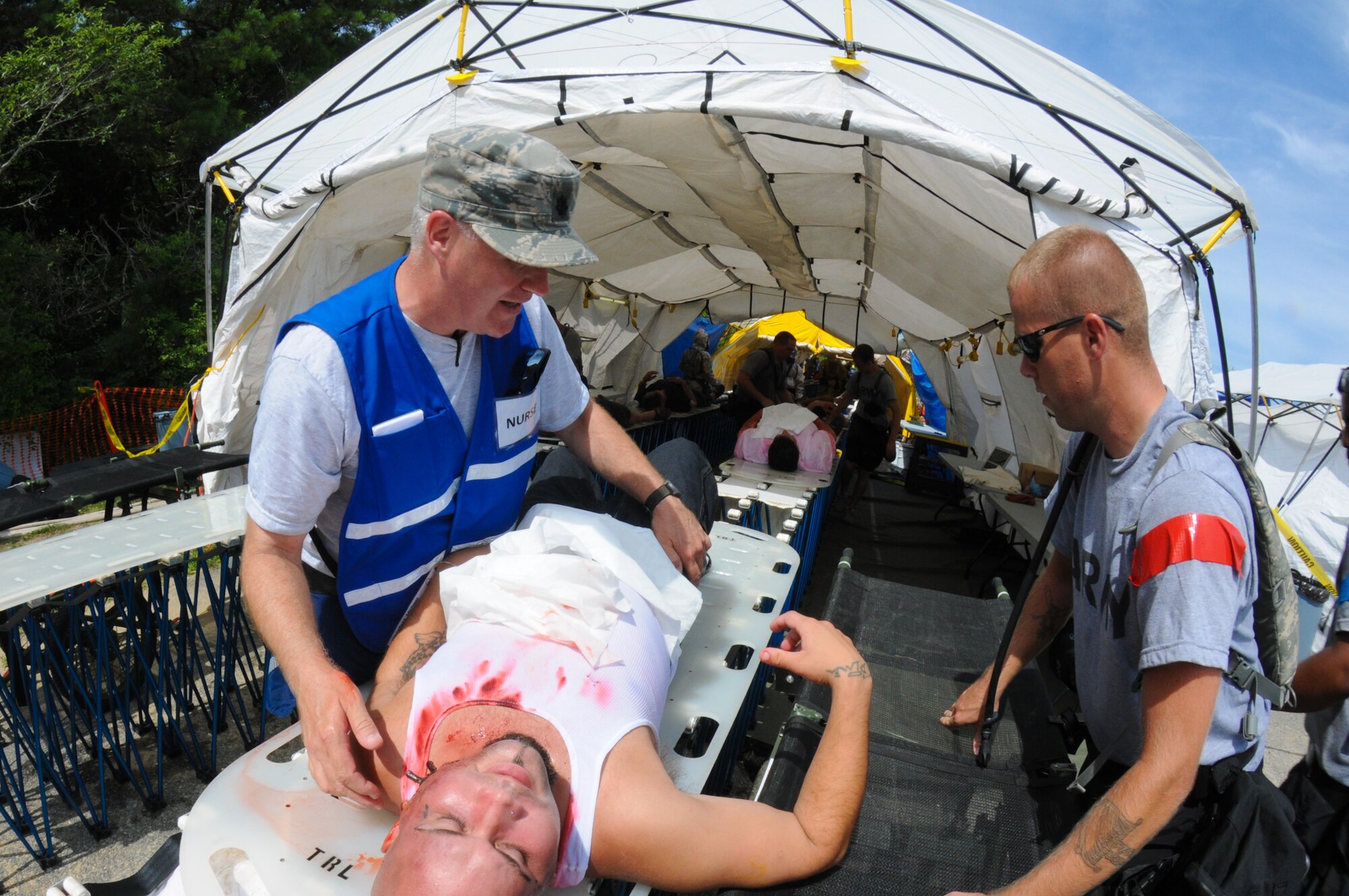 Lt. Col. Stephen VanDaLinda, 102nd Medical Group medical provider, evaluates a patient's condition during the Homeland Response Force (HRF) training exercise at Camp Edwards, Mass., Aug. 8. The exercise, hosted by the Massachusetts National Guard, trains Soldiers and Airmen assigned to the FEMA Region 1 HRF team to respond to a large scale chemical, biological, radiological and nuclear (CBRN) incident in an effort to safeguard lives throughout New England. (National Guard photo by Tech. Sgt. Kerri Cole/Released)