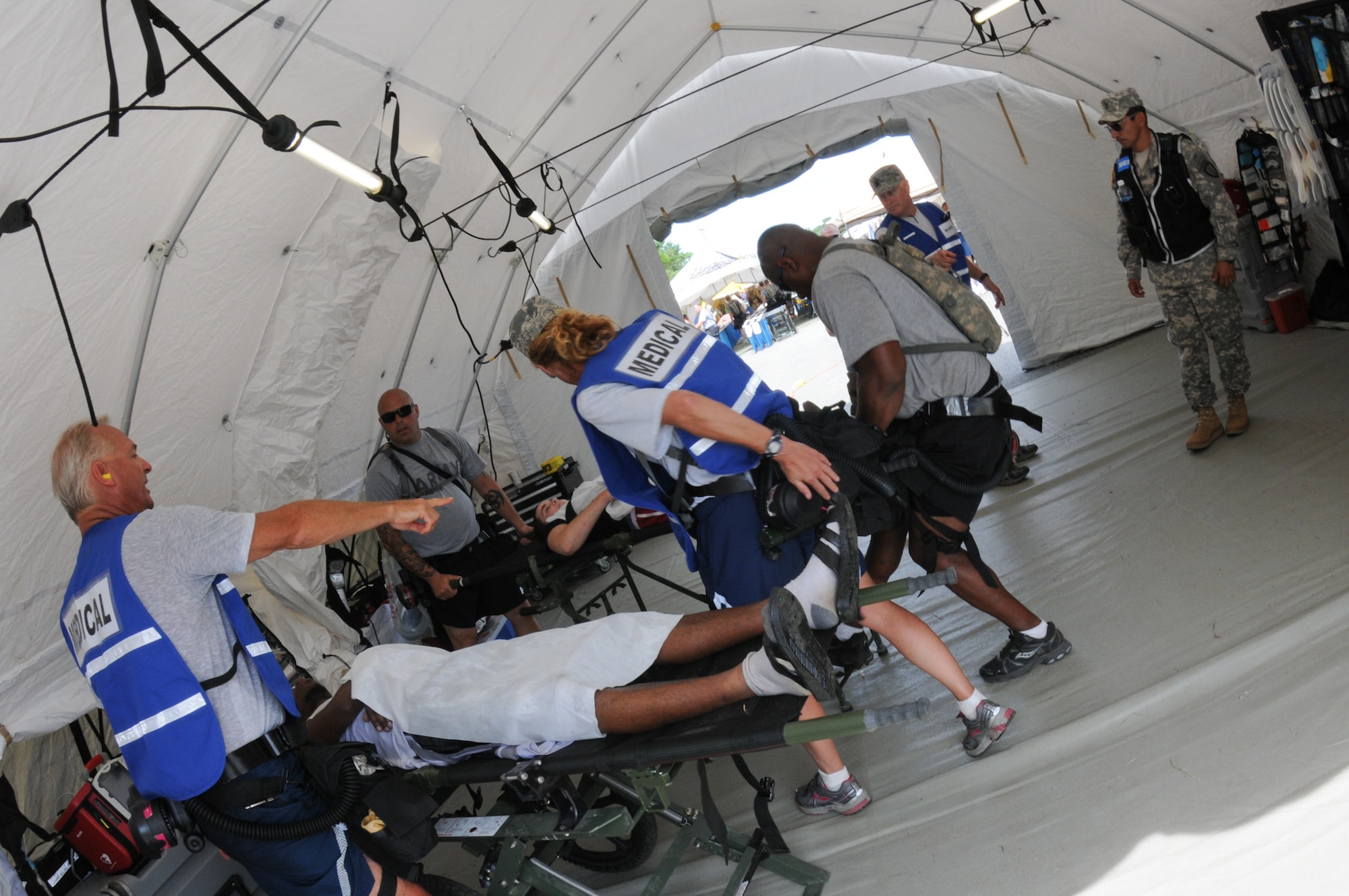 Medical providers from the 102nd Medical Group, evaluate a patient's condition during the Homeland Response Force (HRF) training exercise at Camp Edwards, Mass. Aug. 8. The exercise, hosted by the Massachusetts National Guard,trains Soldiers and Airmen assigned to the FEMA Region 1 HRF team to respond to a large scale CBRN incident in an effort to safeguard lives throughout New England. (National Guard photo by Tech. Sgt. Kerri Cole/Released)