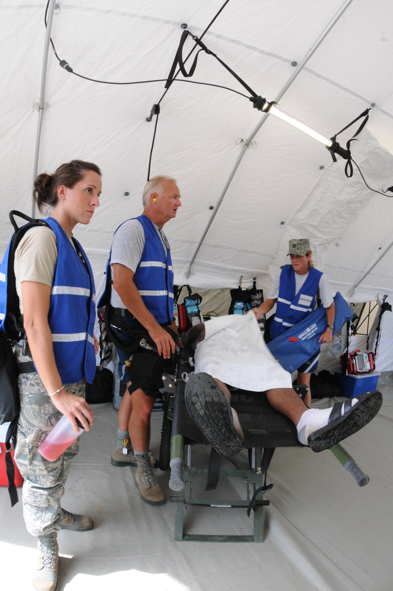 Medical providers from the 102nd Medical Group, evaluate a patient's condition during the Homeland Response Force (HRF) training exercise at Camp Edwards, Mass. Aug. 8. The exercise, hosted by the Massachusetts National Guard,trains Soldiers and Airmen assigned to the FEMA Region 1 HRF team to respond to a large scale CBRN incident in an effort to safeguard lives throughout New England. (National Guard photo by Tech. Sgt. Kerri Cole/Released)