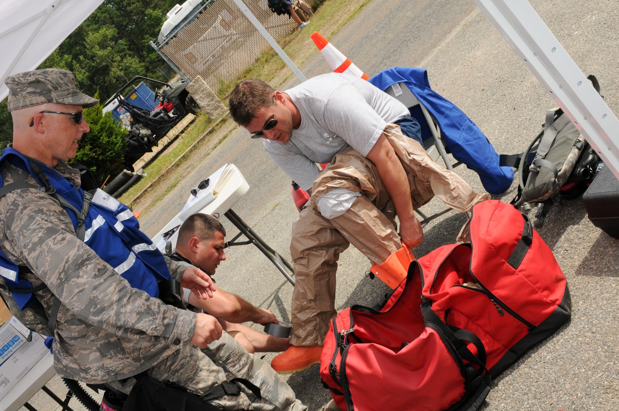 Master Sgt. Joseph Banks, 102nd Medical Group triage technician, dons his decontamination suit during the Homeland Response Force (HRF) training exercise at Camp Edwards, Mass., Aug. 8. The exercise, hosted by the Massachusetts National Guard, trains Soldiers and Airmen assigned to the FEMA Region 1 HRF team to respond to a large scale chemical, biological, radiological and nuclear (CBRN) incident in an effort to safeguard lives throughout New England. (National Guard photo by Tech. Sgt. Kerri Cole/Released)