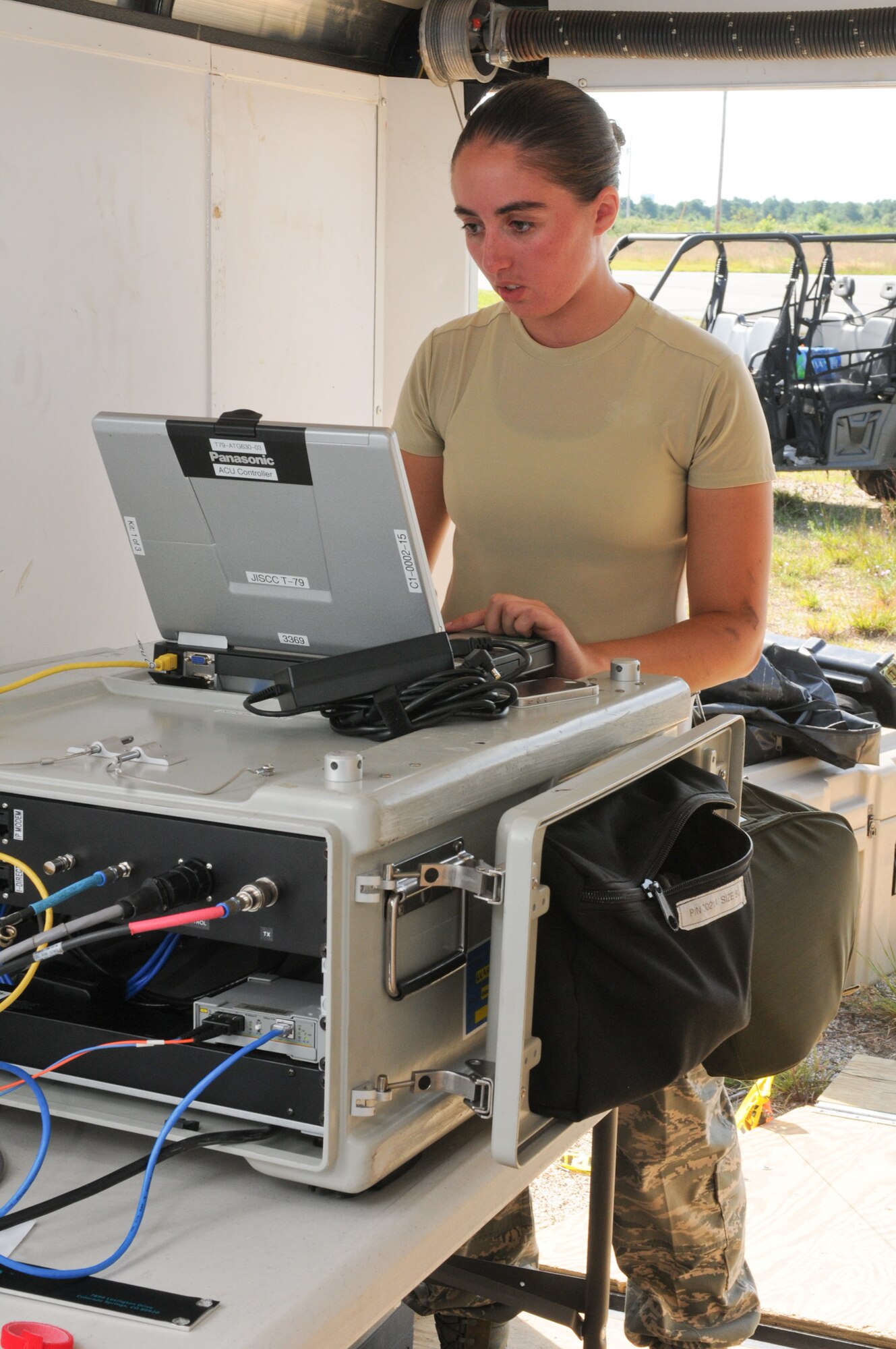 Senior Airman Julia Massi, 267th Combat Communications Squadron (267 CBCS), sets up a modem as part of the Joint Incident Site Communications Capability (JISCC) facility during a Homeland Response Force (HRF) training exercise at Camp Edwards, Mass., Aug. 8. The 267 CBCS provided the primary communication tools for the week-long exercise. (National Guard photo by Tech. Sgt. Kerri Cole/Released)