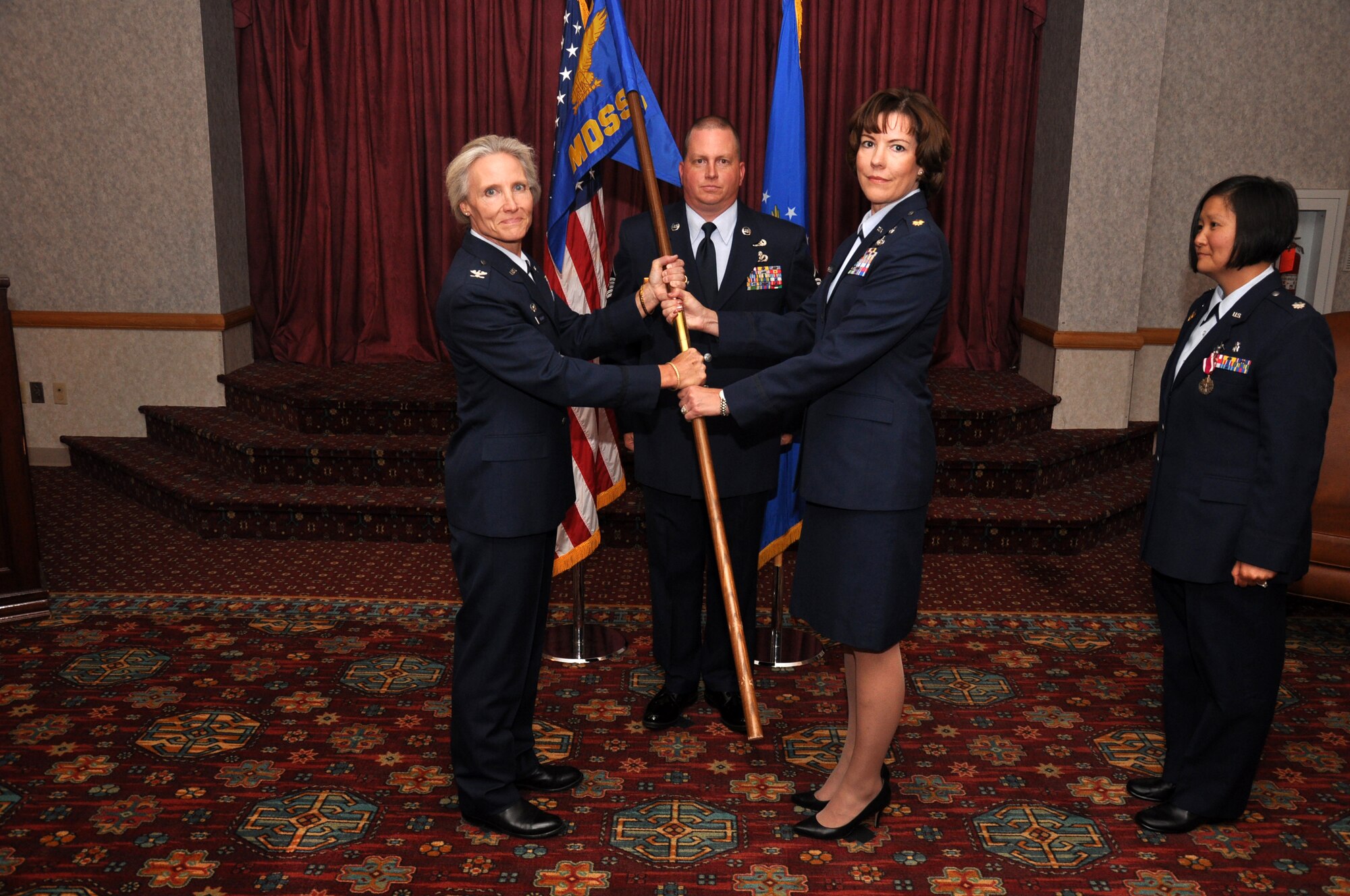 Maj. Joyce Beaty, 90th Medical Support Squadron commander, assumes command of the 90th MDSS upon receiving the guidon from Col. Bridget Gregory, 90th Medical Group commander, during a change of command ceremony at the Trail’s End Club Aug. 10. (U.S. Air Force photo by Senior Airman Dan Gage)