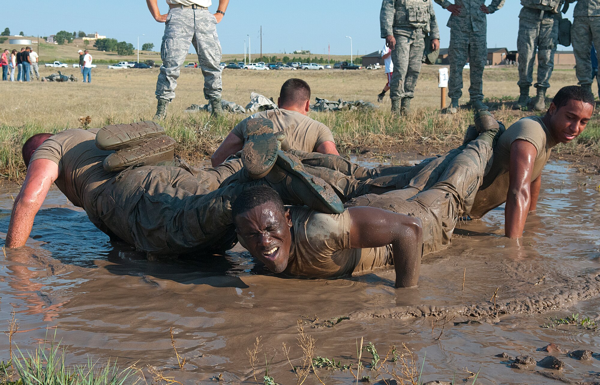 A team from the 790th Missile Security Forces Squadron does team pushups in a mud hole while participating in the Team Pain section of the Crow Creek Challenge Aug. 10. (U.S. Air Force photo by R.J. Oriez) 