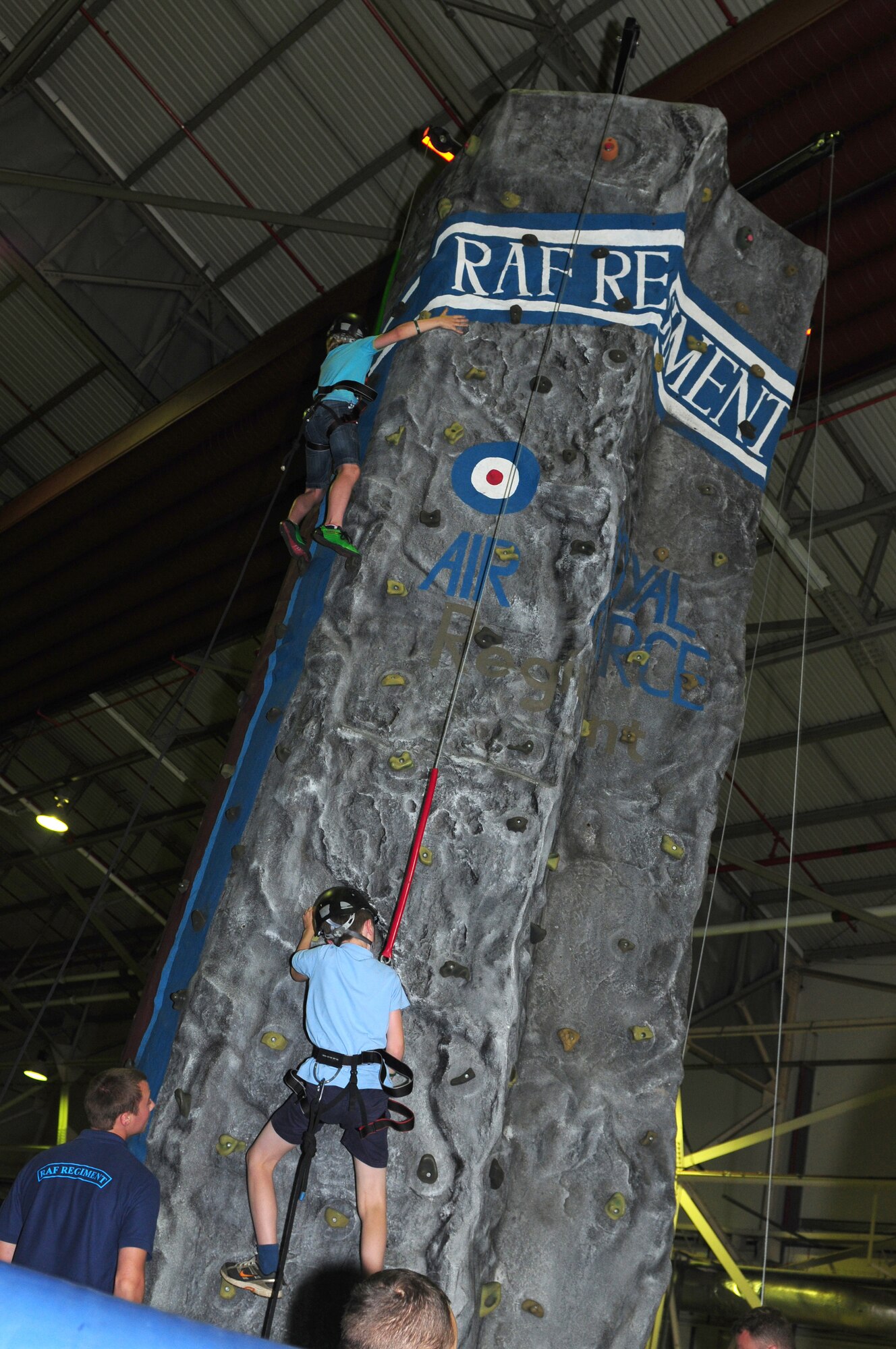 ROYAL AIR FORCE LAKENHEATH, England – Children climb a rock climbing wall provided by the RAF during a joint deployed spouses’ luncheon Aug. 15, 2012. The luncheon featured a booth providing information about the F-15s stationed here, an area where children could try on chemical protective gear and the RAF also provided a close combat virtual reality simulator.  (U.S. Air Force photo by Airman 1st Class Cory D. Payne) 