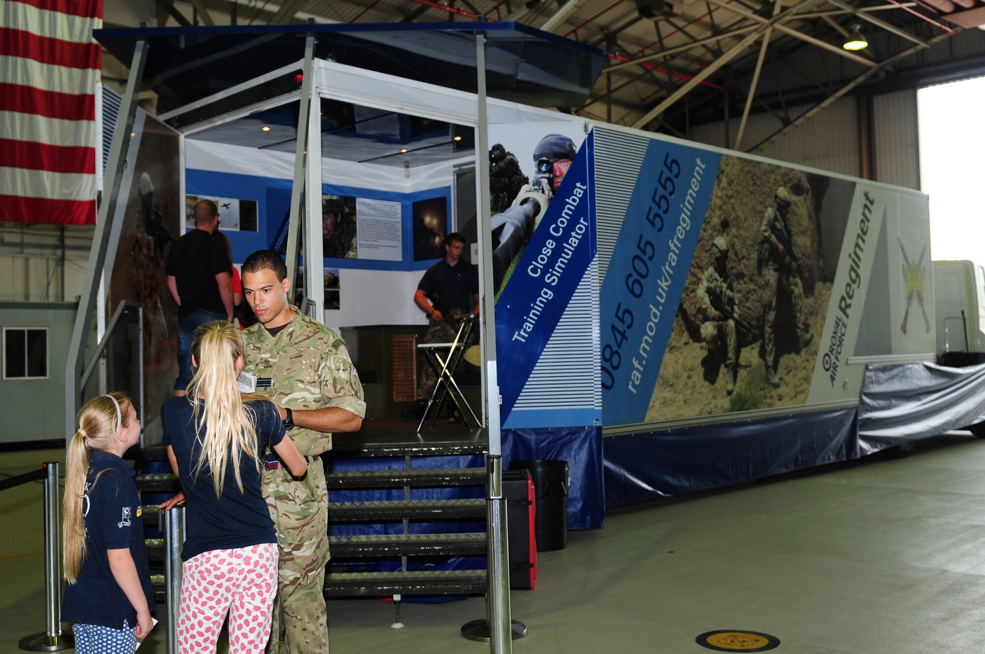 ROYAL AIR FORCE LAKENHEATH, England – Children stand in line for an RAF close combat virtual reality simulator during a joint deployed spouses’ luncheon Aug. 15, 2012. The luncheon featured a booth providing information about the F-15s stationed here, an area where children could try on chemical protective gear, and the RAF also provided a rock climbing wall for children.  (U.S. Air Force photo by Airman 1st Class Cory D. Payne) 