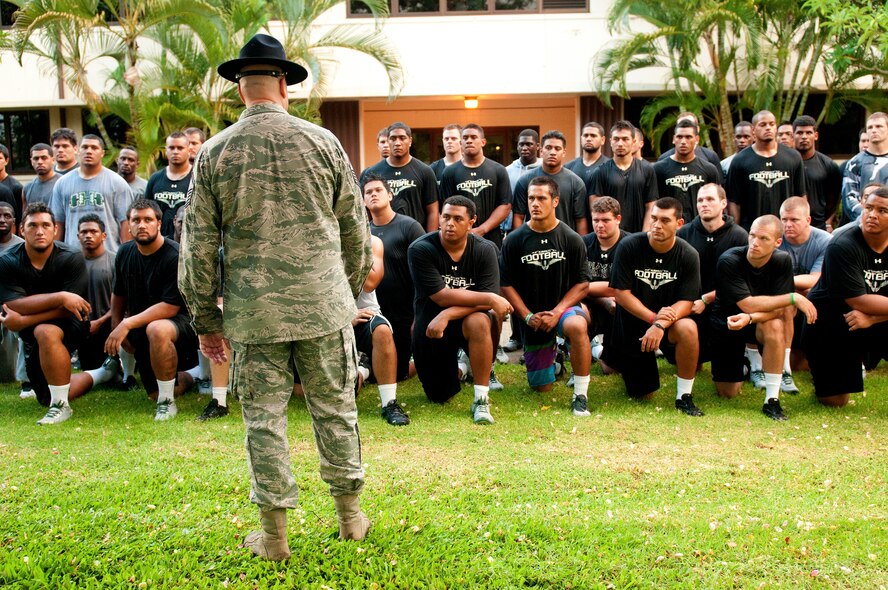 Master Sgt. Gregory Wasson, 647th Security Forces Squadron and former military training instructor, talks to members of the University of Hawaii football team at the Pacific Headquarters building after their 5 a.m. basic training style wake-up call and physical training session Aug. 14 at Joint Base Pearl Harbor-Hickam. Air Force and Navy servicemembers took part in a team building exercise with the team for an early morning physical training session. The Warriors are scheduled to be on the road for their opener Sept. 1, in Los Angeles, against the University of Southern California Trojans. (U.S. Air Force photo/Staff Sgt. Mike Meares)