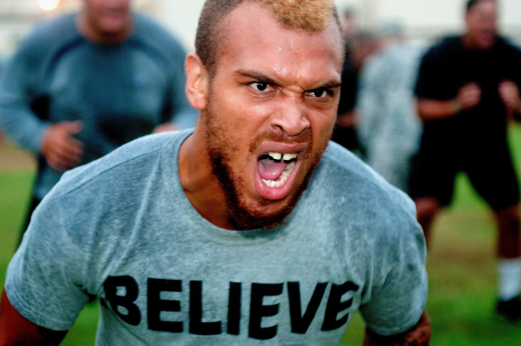 Tony Grimes, University of Hawaii junior defensive back, raises his intensity on command during a military-led physical training session Aug. 14 at Joint Base Pearl Harbor-Hickam.  Former Air Force and Navy basic military training instructors gave a very special wake-up call to the University of Hawaii football team shortly after 5 a.m. Aug. 14 for a team building exercise. (U.S. Air Force photo/Staff Sgt. Mike Meares)