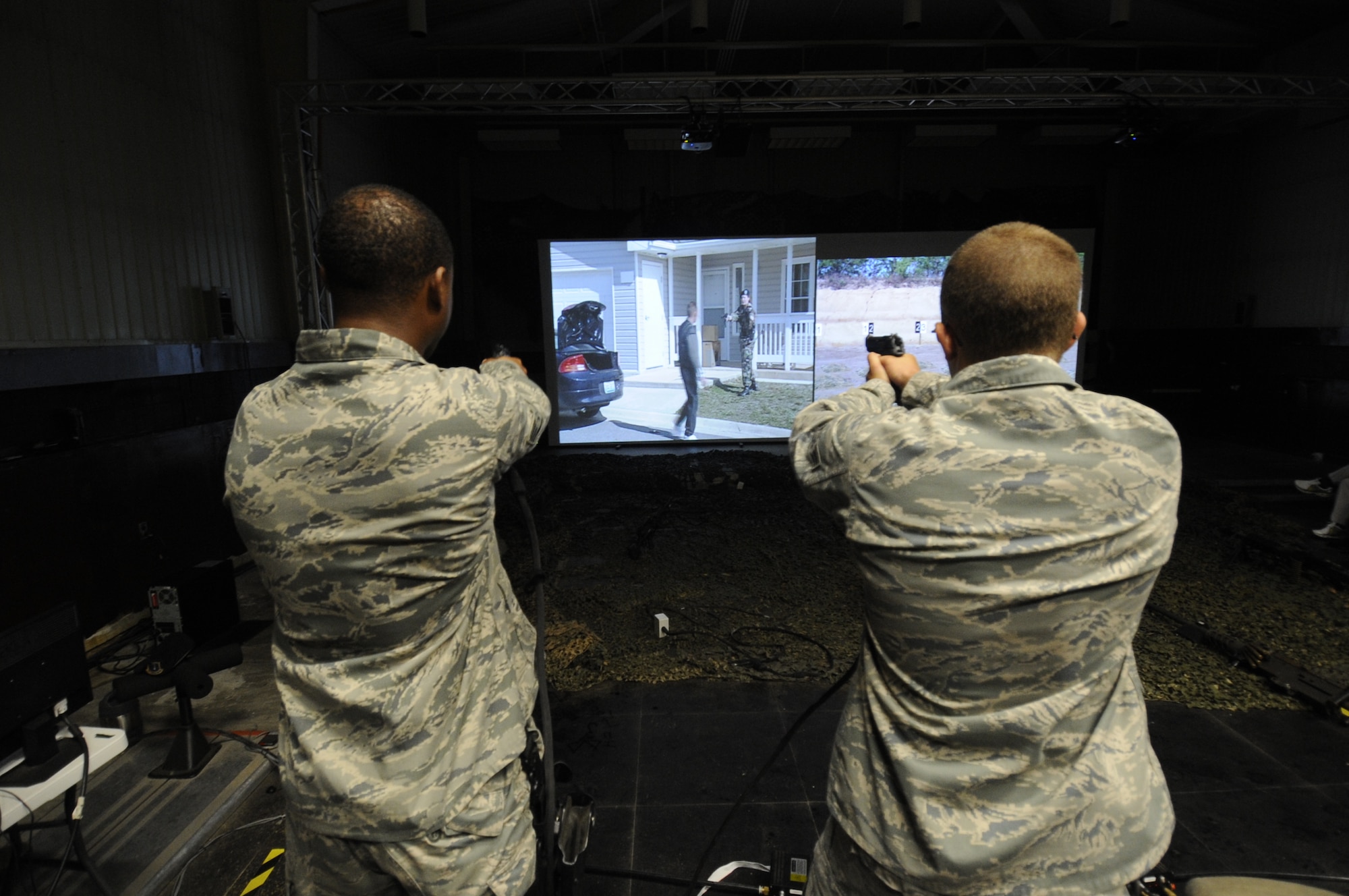 Airmen from the 8th Security Forces Squadron complete a training scenario using a firearms training simulator on Kunsan Air Base, Republic of Korea, Aug. 10, 2012. The FATS machine helps security forces personnel practice essential marksmanship skills, as well as shoot/don't shoot training objectives. (U.S. Air Force photo/Senior Airman Jessica Hines)