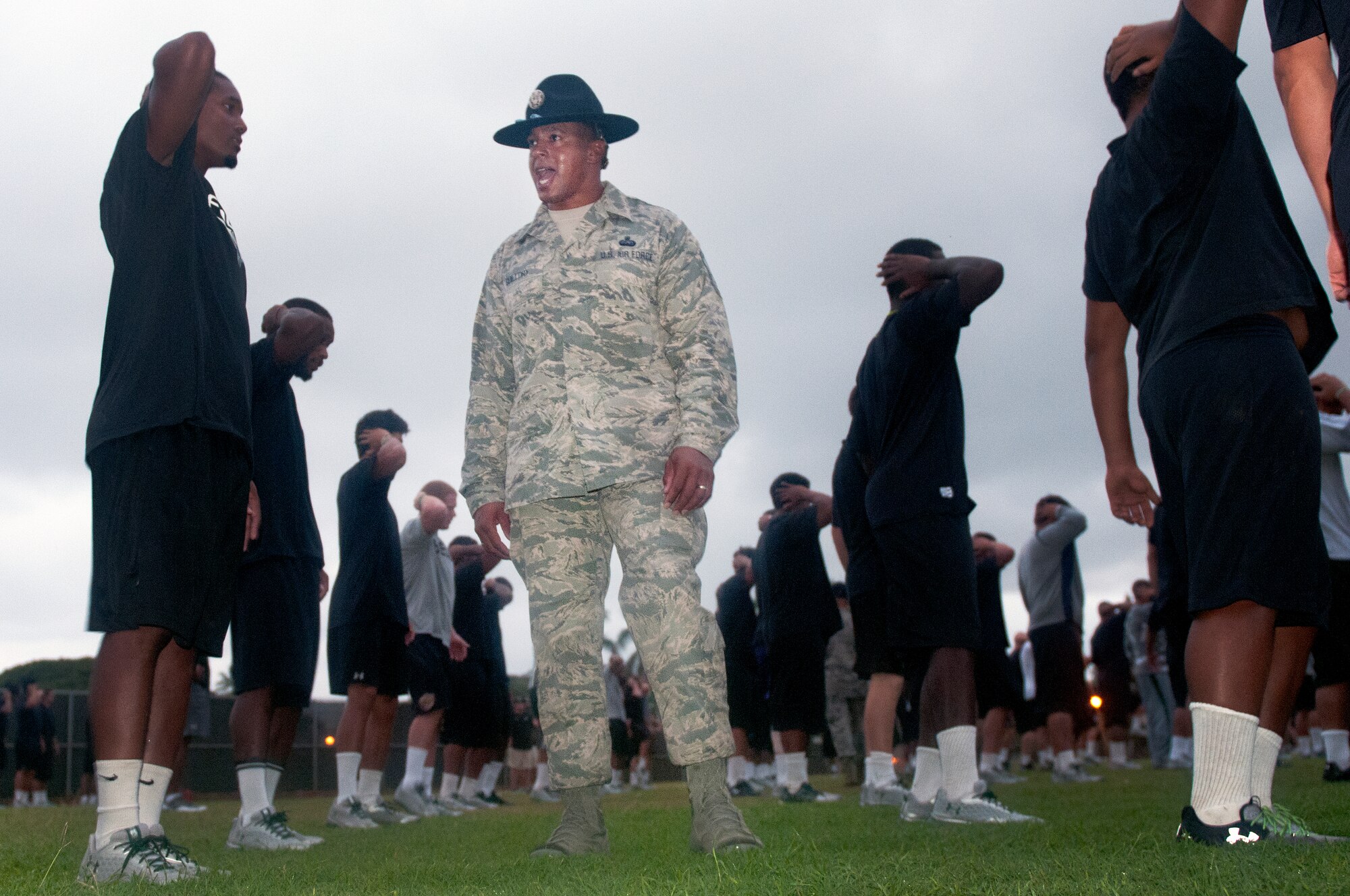 Senior Master Guillory, 56th Air and Space Communications Squadron and former military training instructor, motivates University of Hawaii football players during the physical training session after their 5 a.m. basic training style wake-up call Aug. 14 at Joint Base Pearl Harbor-Hickam. Air Force and Navy servicemembers took part in a team building exercise with the team for an early morning physical training session. The Warriors are scheduled to be on the road for their opener Sept. 1, in Los Angeles, against the University of Southern California Trojans. (U.S. Air Force photo/Staff Sgt. Mike Meares)