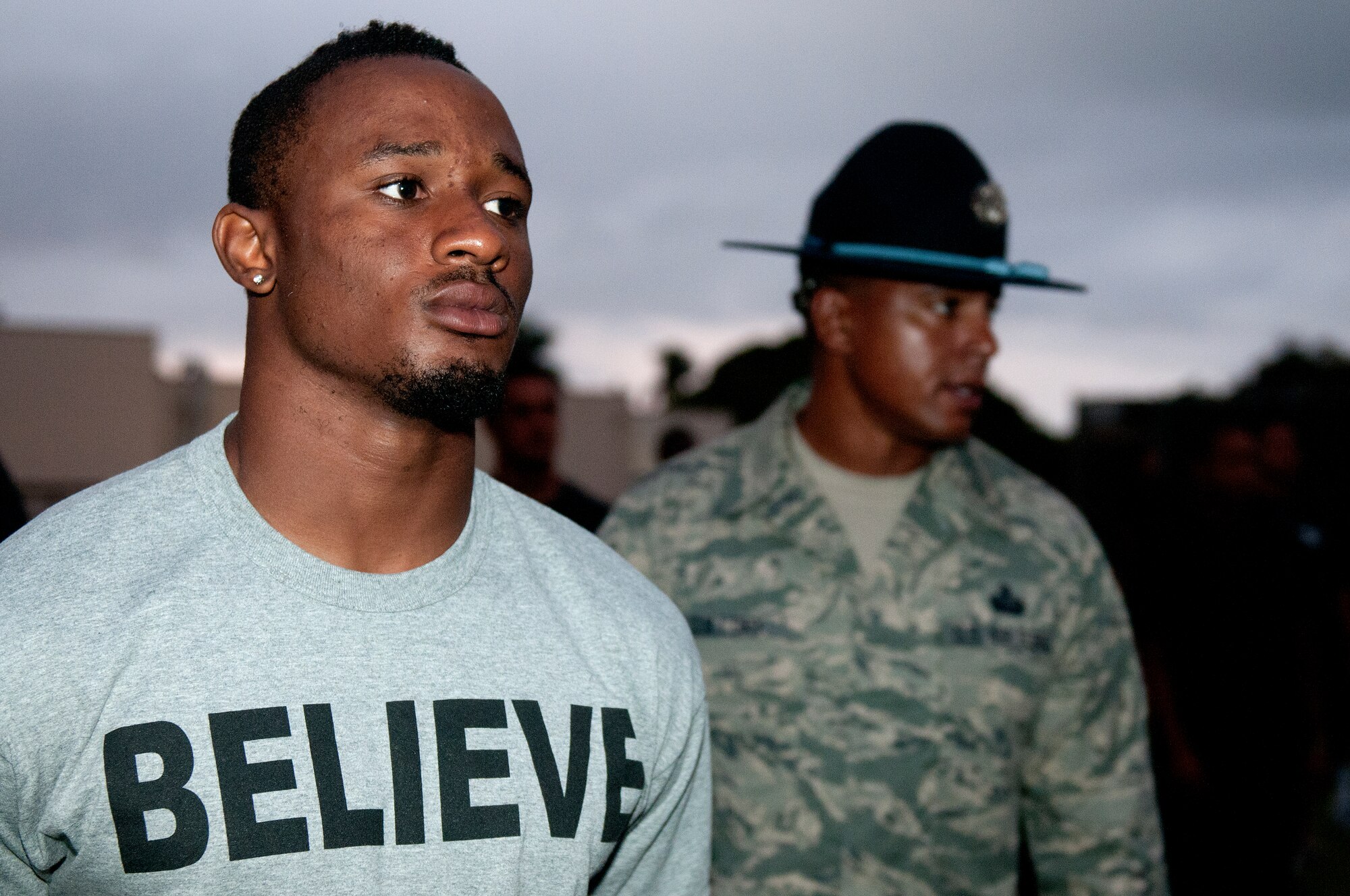 University of Hawaii junior defensive back Mike Edwards, keeps his head and eyes forward as Senior Master Guillory, 56th Air and Space Communications Squadron and former military training instructor, lurks behind him during the physical training session after their 5 a.m. basic training style wake-up call Aug. 14 at Joint Base Pearl Harbor-Hickam. Air Force and Navy servicemembers took part in a team building exercise with the team for an early morning physical training session. The Warriors are scheduled to be on the road for their opener Sept. 1, in Los Angeles, against the University of Southern California Trojans. (U.S. Air Force photo/Staff Sgt. Mike Meares)