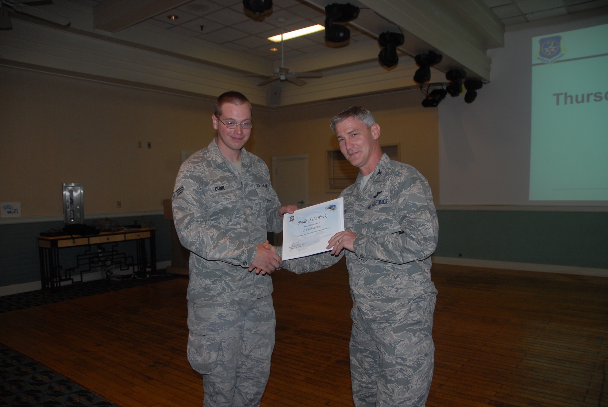 Col. John Pearse, 8th Fighter Wing commander, presents Senior Airman Joshua Dunn, 8th Logistics Readiness Squadron, with a Pride of the Pack award Aug. 16, 2012. Pride of the Pack recognized the outstanding work Wolf Pack Airmen do everyday. (U.S. Air Force photo/Capt. Sheila Johnston) 
