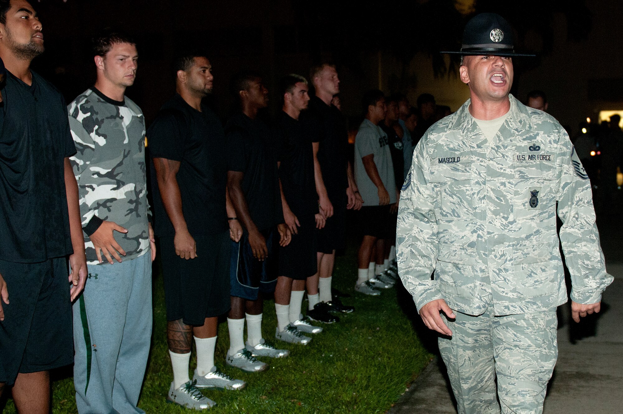Master Sgt. John Mascolo, 647th Security Forces Squadron and former military training instructor, yells out instructions for the University of Hawaii football players shortly after 5 a.m. during a basic training style wake-up call Aug. 14 at Joint Base Pearl Harbor-Hickam. Air Force and Navy servicemembers took part in a team building exercise with the team for an early morning physical training session. The Warriors are scheduled to be on the road for their opener Sept. 1, in Los Angeles, against the University of Southern California Trojans. (U.S. Air Force photo/Staff Sgt. Mike Meares)