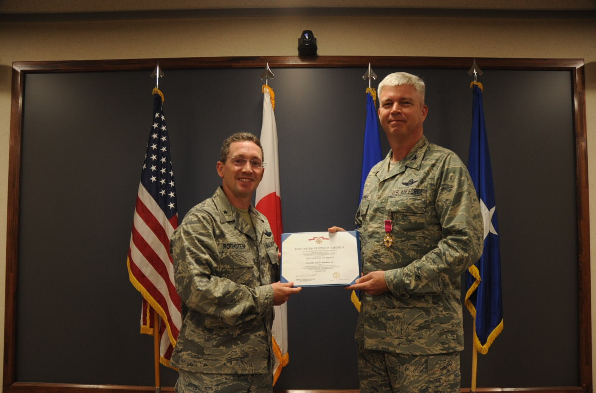 U.S. Air Force Col. Al Wimmer, right, 35th Fighter Wing vice commander, receives the Legion of Merit and certificate from Brig. Gen. Michael Rothstein, 35th Fighter Wing commander, at Misawa Air Base, Japan, Aug. 16, 2012. Wimmer served as the vice commander since July 2010 and will move to his next assignment at the 325th Fighter Wing, Tyndall Air Force Base, Fla. (U.S. Air Force photo by Airman 1st Class Kenna Jackson/Released)