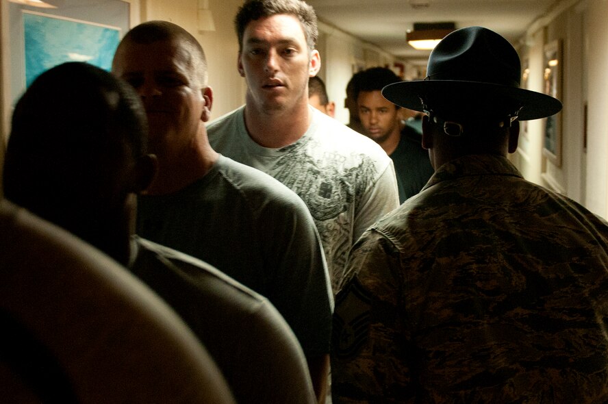 Senior Master Guillory, 56th Air and Space Communications Squadron and former military training instructor, lines up University of Hawaii football players shortly after 5 a.m. during a basic training style wake-up call Aug. 14 at Joint Base Pearl Harbor-Hickam. Air Force and Navy servicemembers took part in a team building exercise with the team for an early morning physical training session. The Warriors are scheduled to be on the road for their opener Sept. 1, in Los Angeles, against the University of Southern California Trojans. (U.S. Air Force photo/Staff Sgt. Mike Meares)