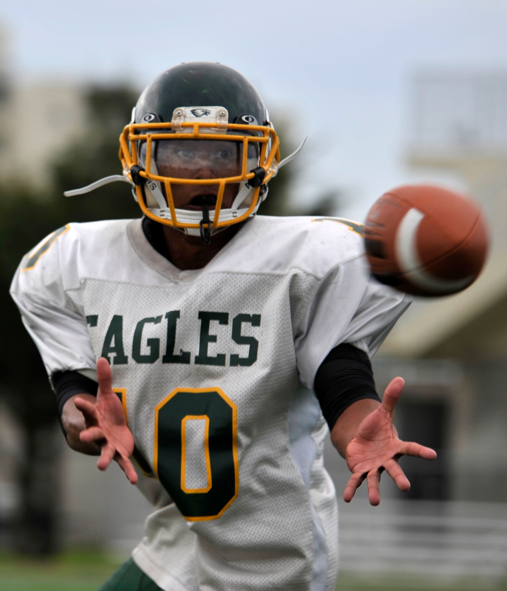 Aric Butterfield, Edgren Eagles running back and wide receiver, catches a football during the Edgren High School football team practice at Misawa Air Base, Japan, Aug. 15, 2012. Edgren High is in their first week of full pads at practice and is preparing for their first game against defending champions Yokota on Aug. 24, 2012. (U.S. Air Force photo by Airman 1st Class Zachary Kee/Released)