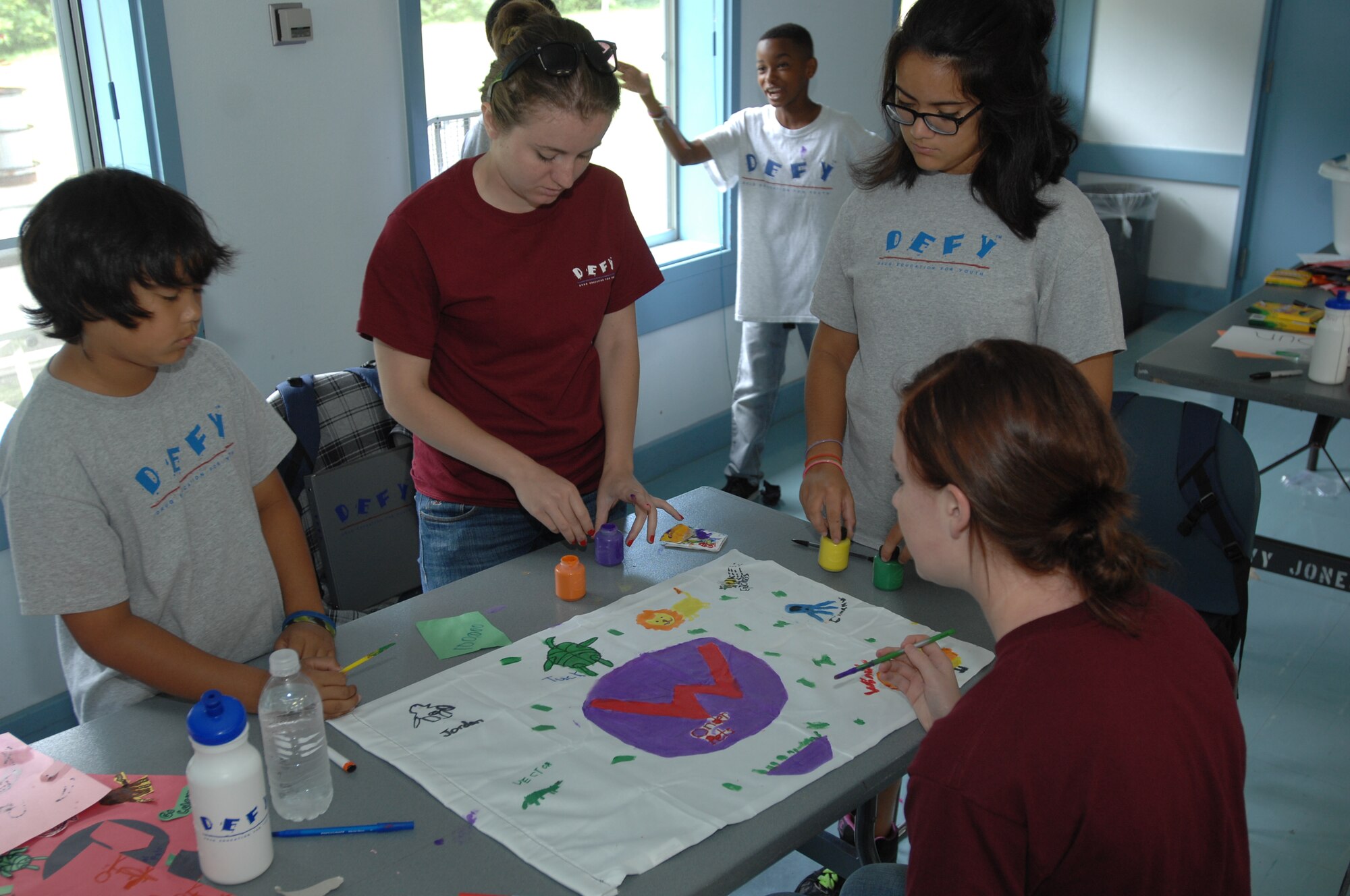 From left, Josiah Millare, age 10, from Chula Vista, Calif., Cryptologic Technician (Technician) Seaman Lavdjola Fasho, originally from Tirana, Albania, Saylor Lopez, age 12, from Fort Worth, Texas, and Cryptologic Technician (Technician) Seaman Apprentice Samantha Willy, a Spokane, Wash. native, create a flag during Drug Education for Youth (DEFY) camp at Naval Air Facility Misawa, Japan, Aug. 8, 2012. The Misawa DEFY program was organized and coordinated by Sailors attached to Navy Information Operations Command Misawa, who spent the past eight days conducting this non-residential, drug prevention camp for kids ages 9-12.  (U.S. Navy photo by Senior Chief Mass Communication Specialist Daniel Sanford/Released)
