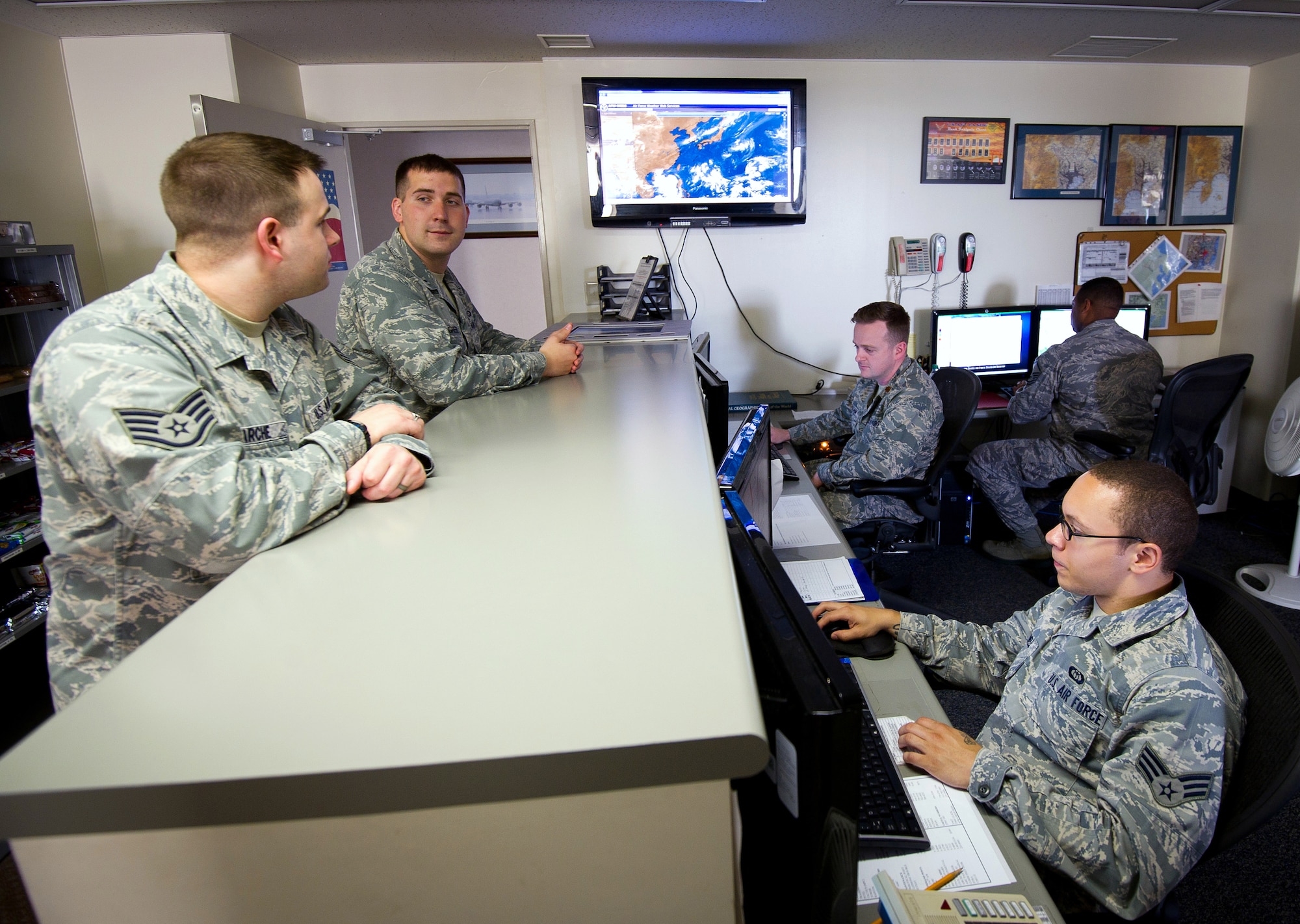 YOKOTA AIR BASE, Japan -- Members of the 374th Operations Support Squadron weather flight discuss weather conditions throughout Japan Aug. 16, 2012, at Yokota Air Base, Japan. Weather personnel must know the current weather conditions in order to properly inform the Yokota community. (U.S. Air Force photo by Staff Sgt. Chad C. Strohmeyer)