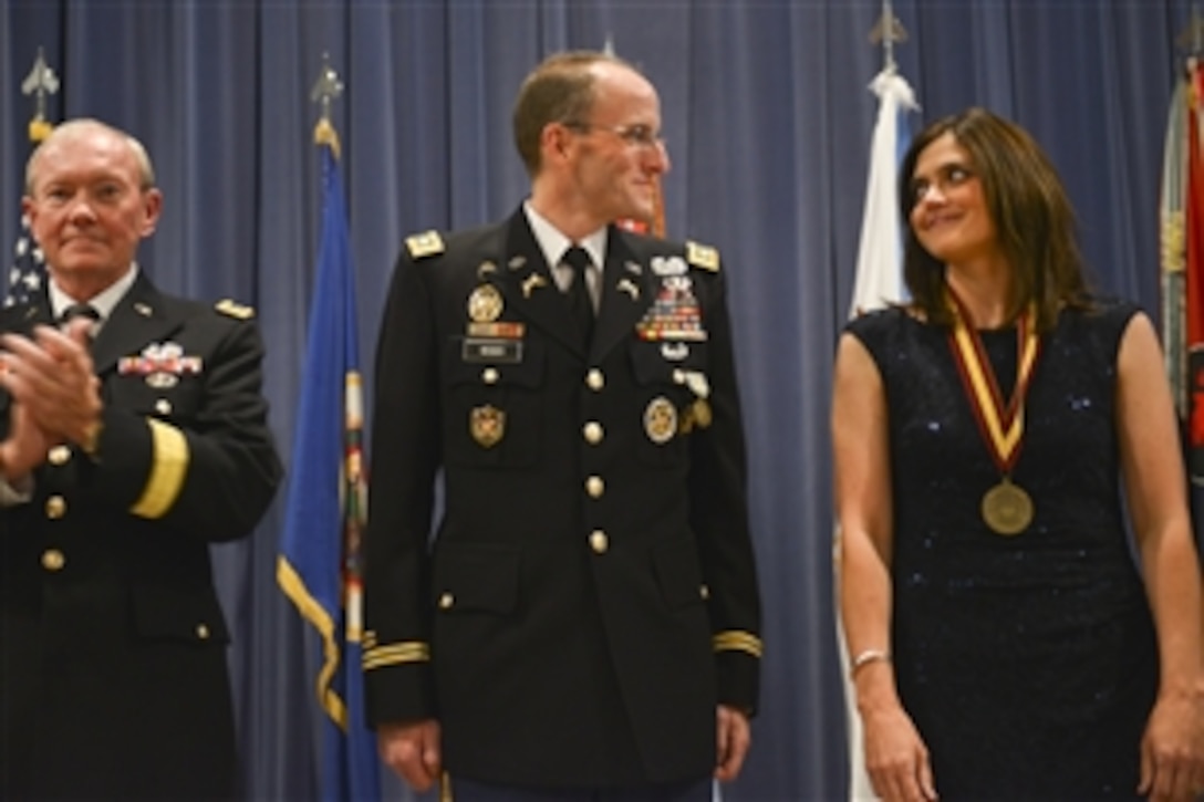 Army Gen. Martin E. Dempsey, left, chairman of the Joint Chiefs of Staff, applauds U.S. Army Lt. Col. Mark Weber, center, and his wife, Kristen, during Weber's end of service ceremony at the Minnesota National Guard Armory in Rosemount, Minn., Aug. 16, 2012. 