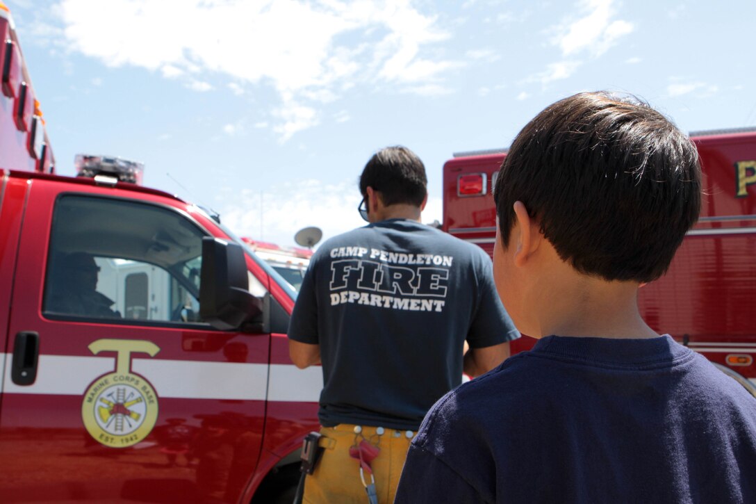 Kaden Rivera, 6, watches the Camp Pendleton Fire Department get ready as they respond to a call during the luncheon in his honor at Fire Station 8 on Camp Pendleton, Aug. 18. The luncheon was held to honor the fire crew that responded to Rivera's life threatening emergency and to recognize him as an honorary firefighter.