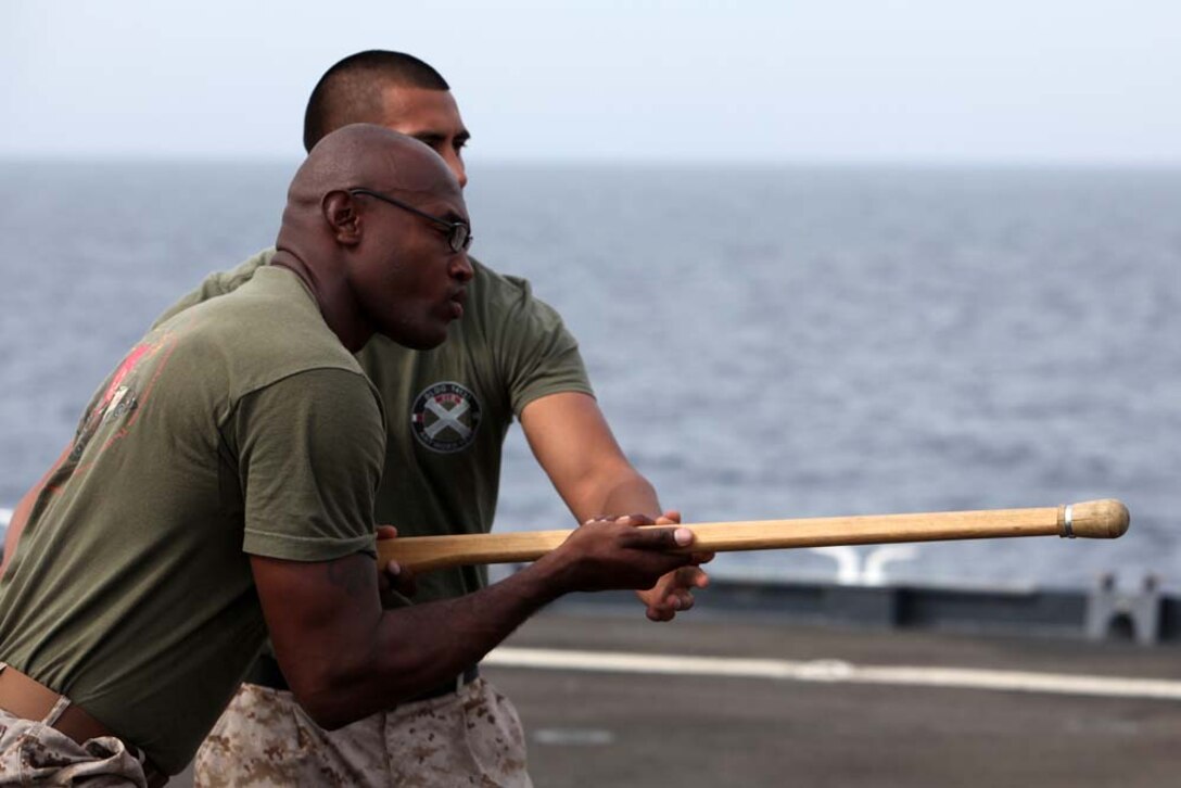 Sergeant Nathaniel McDonald (front), motor transportation specialist, Transportation Support Detachment, Combat Logistics Battalion 15, 15th Marine Expeditionary Unit, and Sgt. Andy Alonso, the landing support chief with the unit, demonstrate bayonet techniques in the Marine Corps Martial Arts Program on the flight deck of the USS Rushmore, Aug. 16. The 15th MEU is embarked as part of the Peleliu Amphibious Ready Group during Certification Exercise, their final training before their deployment this fall. Alonso, 25, and McDonald, 28, are both from New York City.